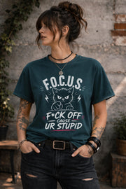 Woman wearing dark gray sarcastic cat graphic t-shirt with bold funny text outdoors
