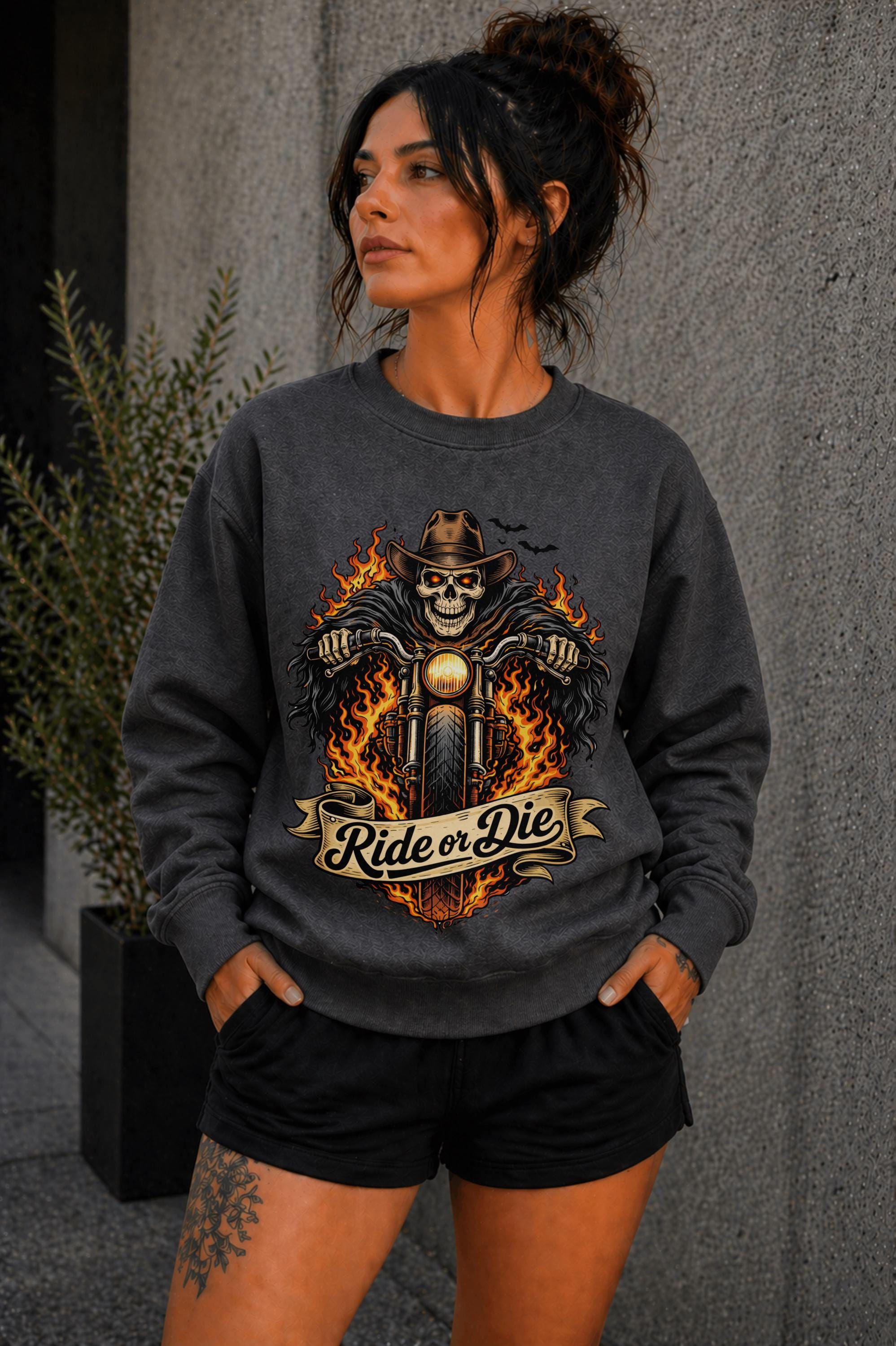 Woman wearing navy biker graphic shirt with skull motorcycle ride or die design