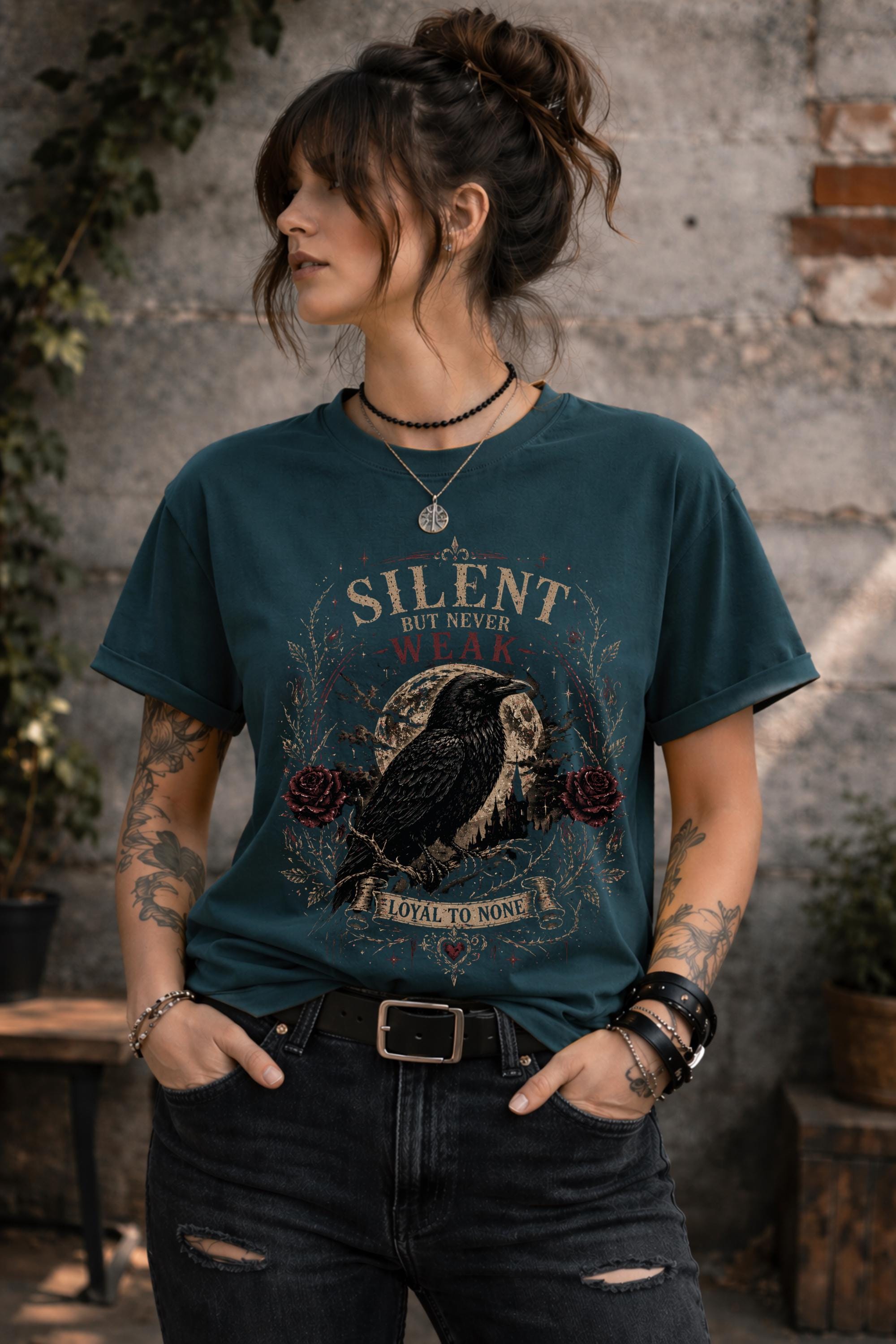 Woman wearing gothic raven shirt in moody outdoor setting, dark academia fashion with edgy alternative style