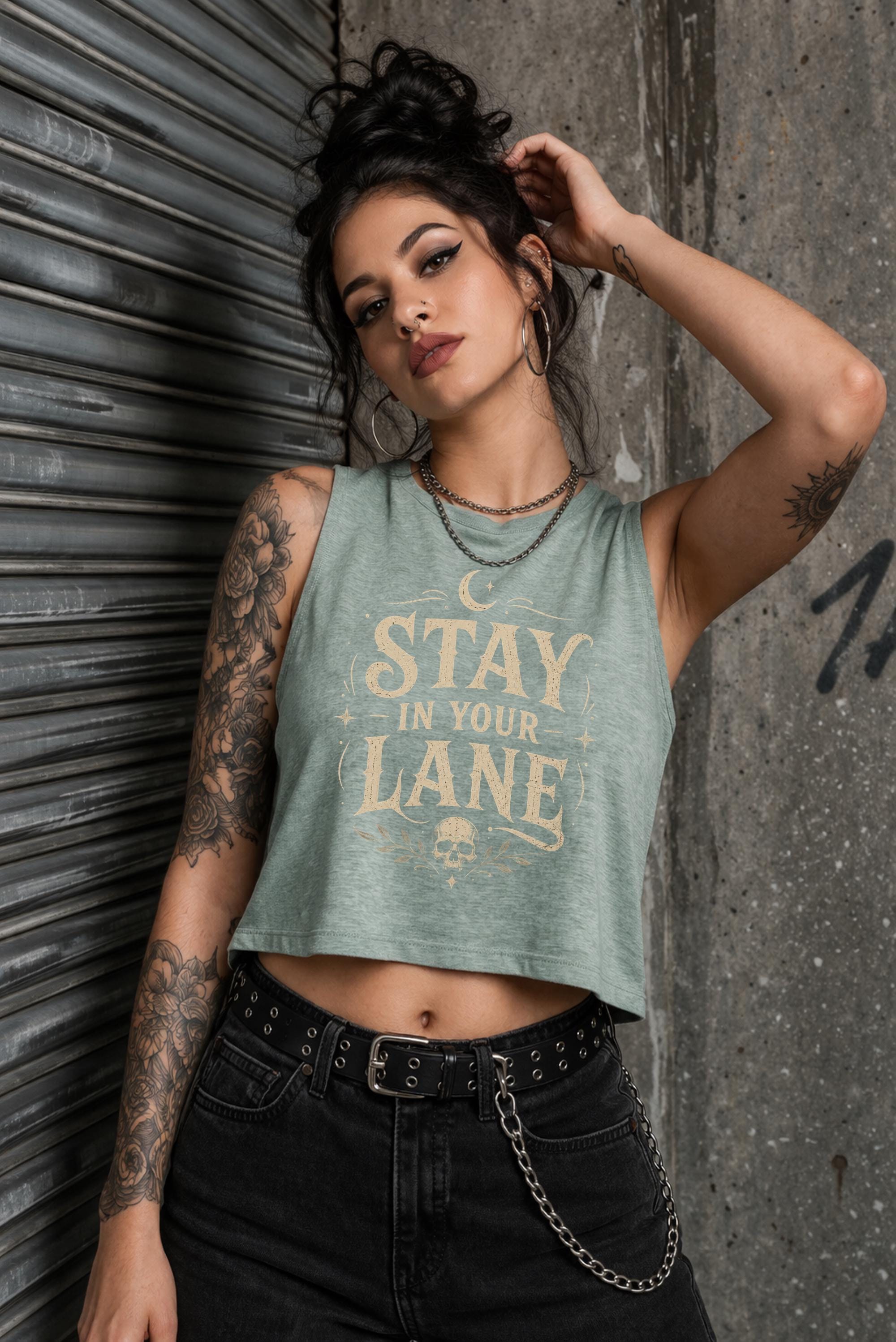 Woman wearing cropped Stay In Your Lane graphic tank with bold gothic lettering and alternative fashion styling