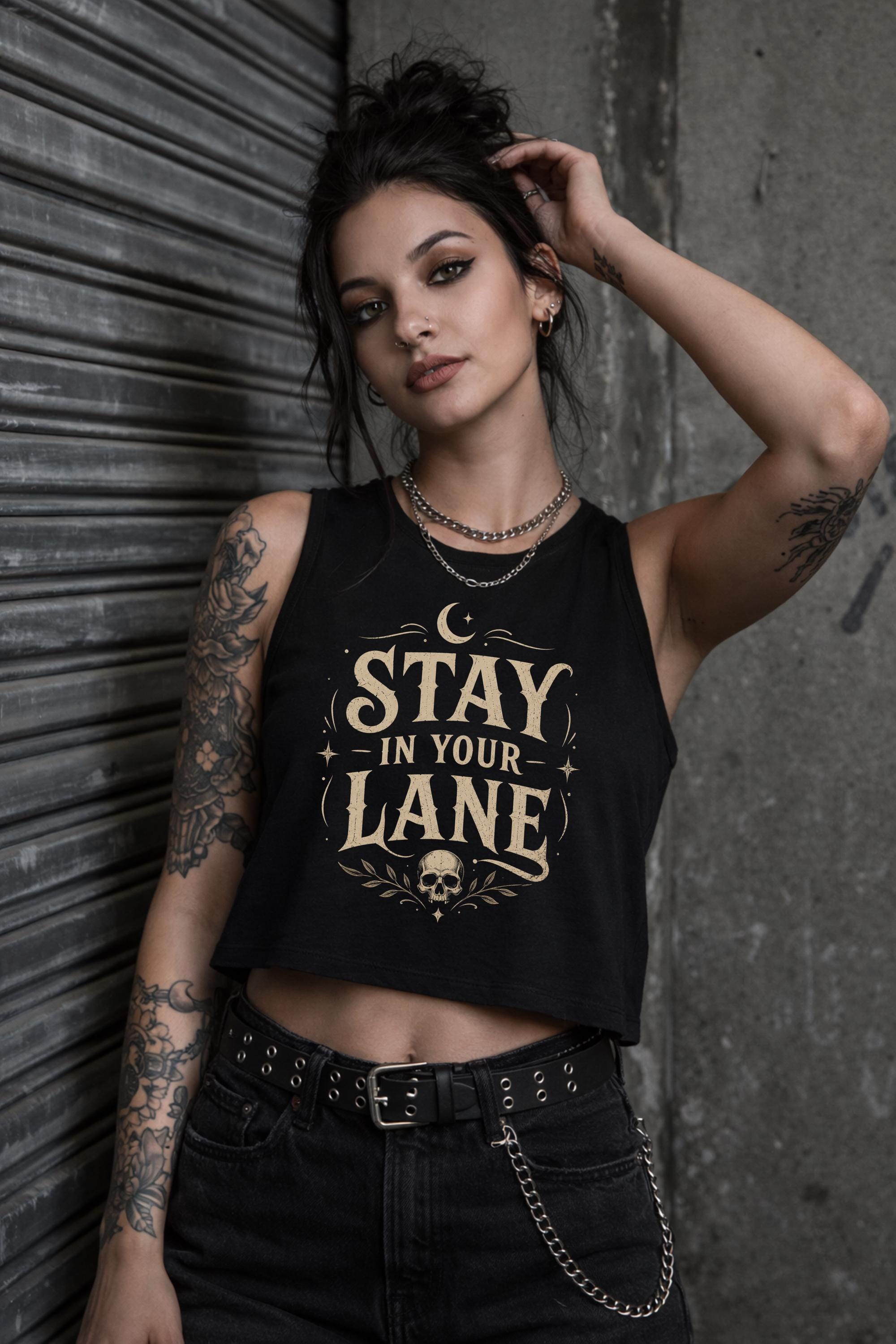 Woman wearing black cropped Stay In Your Lane graphic tank with bold gothic lettering and alternative fashion styling