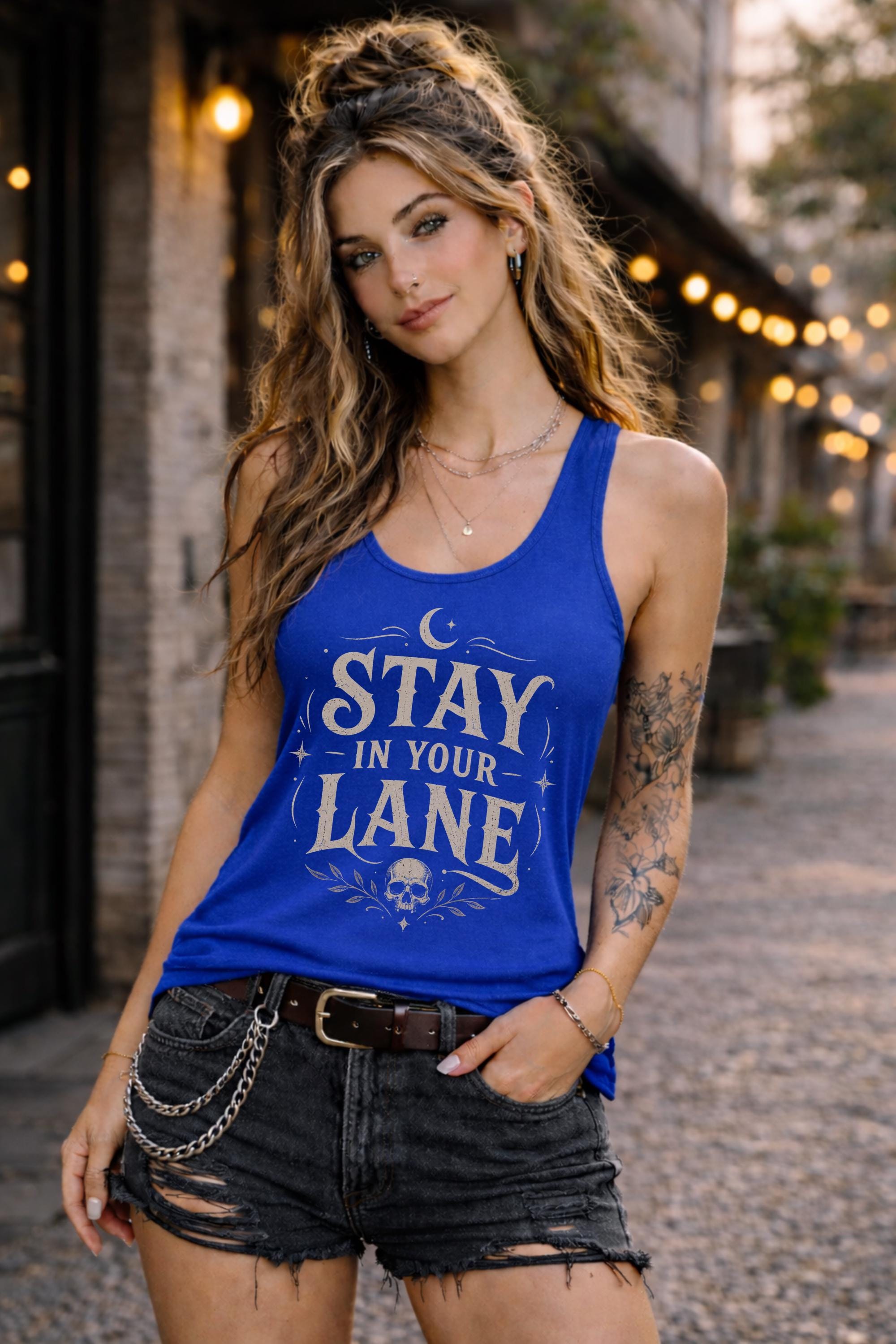 Woman wearing navy Stay In Your Lane graphic racerback tank with edgy gothic typography and skull detail