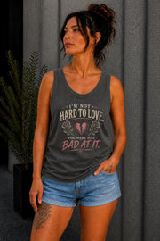 Woman wearing a graphic tank top with sarcastic breakup quote I’m Not Hard to Love You Were Just Bad At It with broken heart design