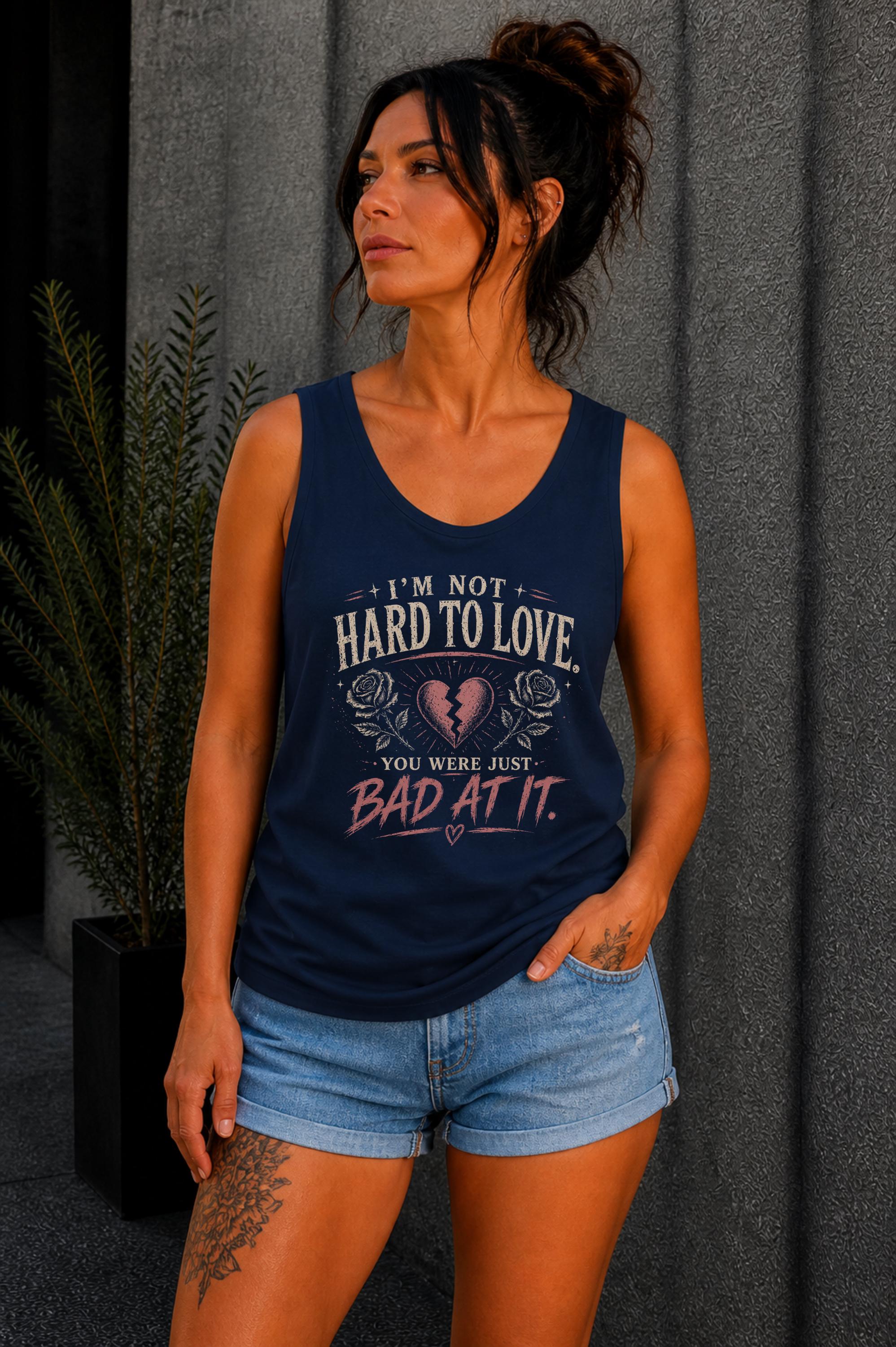 Woman wearing navy graphic tank top with sarcastic breakup quote I’m Not Hard to Love You Were Just Bad At It with broken heart design