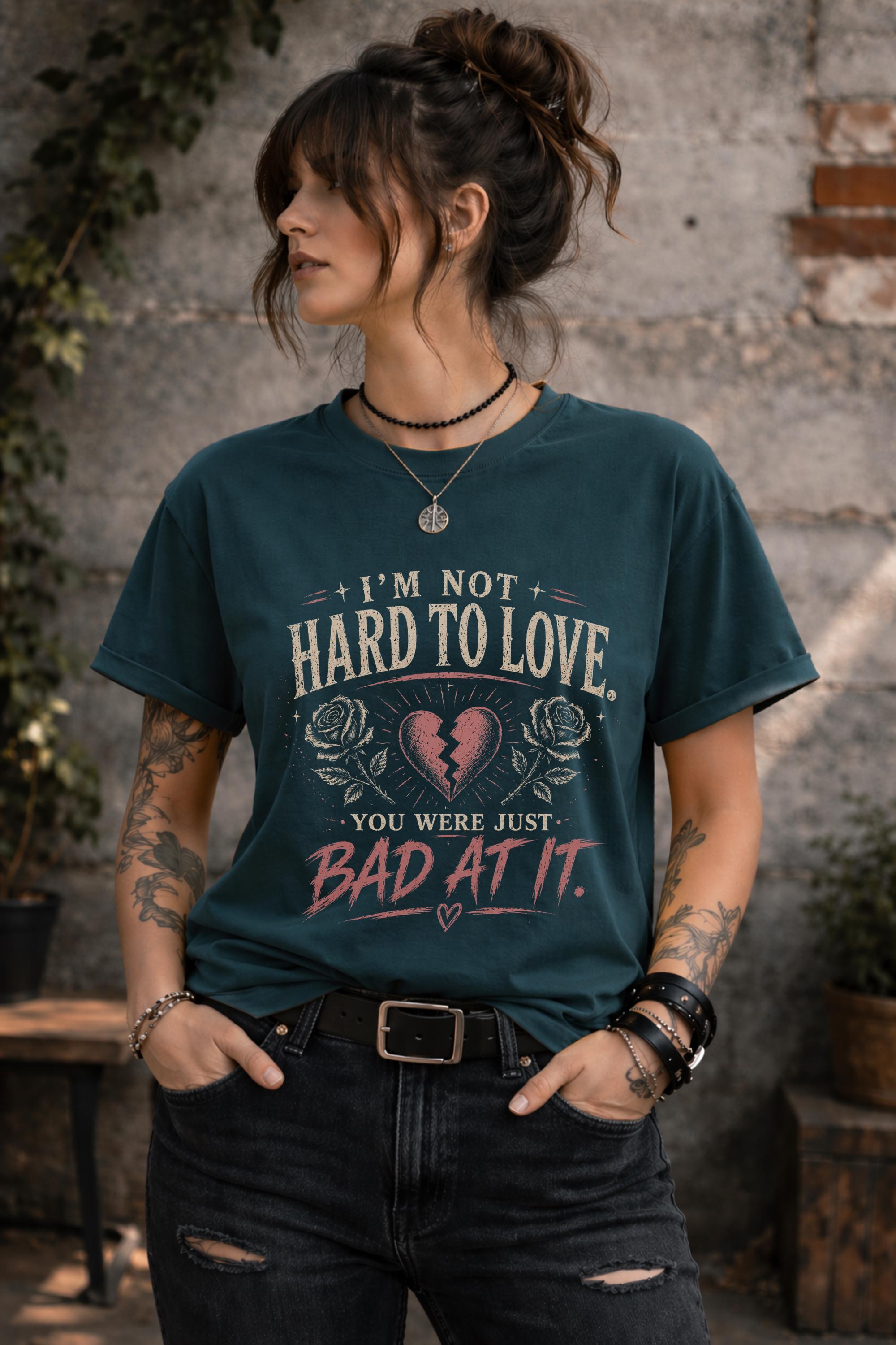 Woman wearing navy graphic t-shirt with sarcastic breakup quote I’m Not Hard to Love You Were Just Bad At It with broken heart design