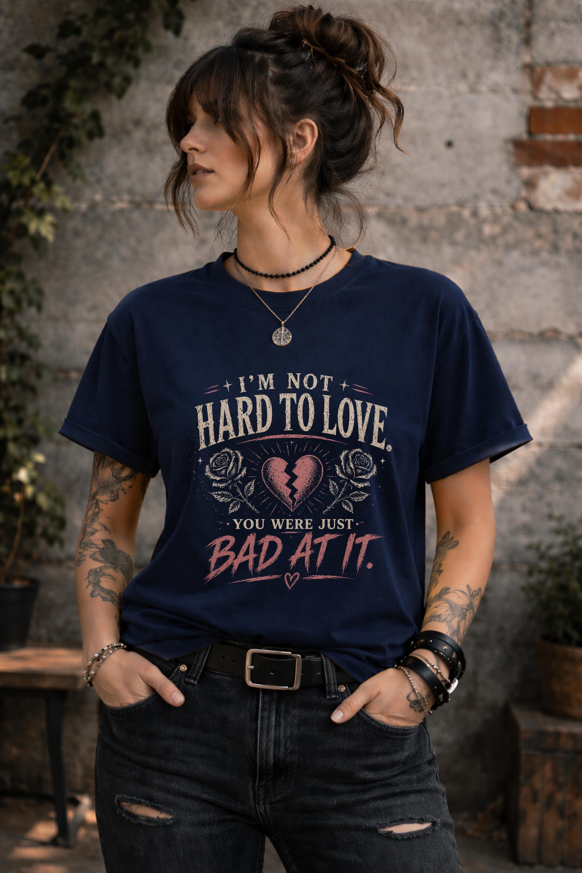 Woman wearing navy graphic t-shirt with sarcastic breakup quote I’m Not Hard to Love You Were Just Bad At It with broken heart design