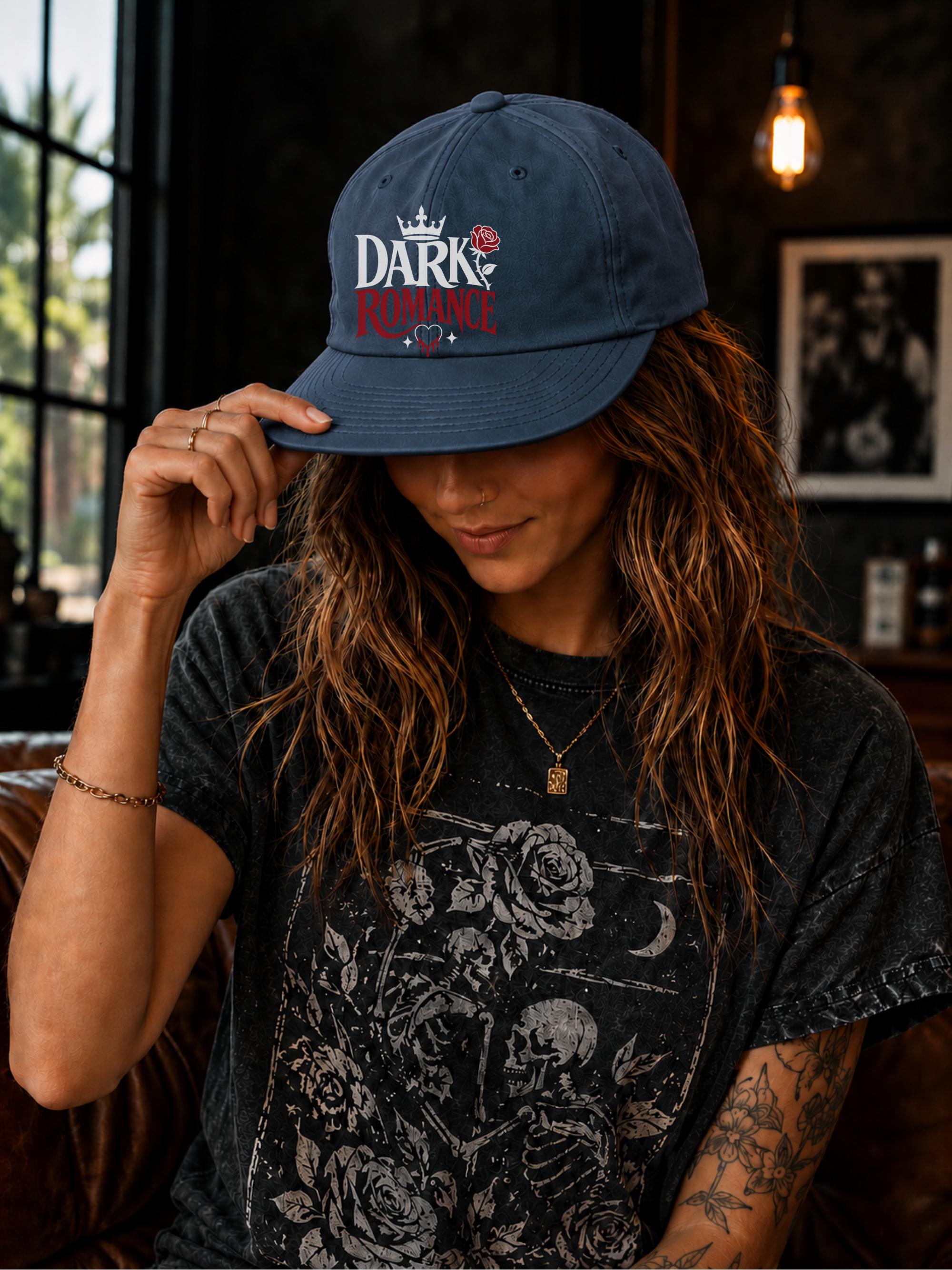 Woman wearing a surf cap featuring a Dark Romance graphic with red rose detail, photographed in a moody bookish setting with dark academia aesthetic.
