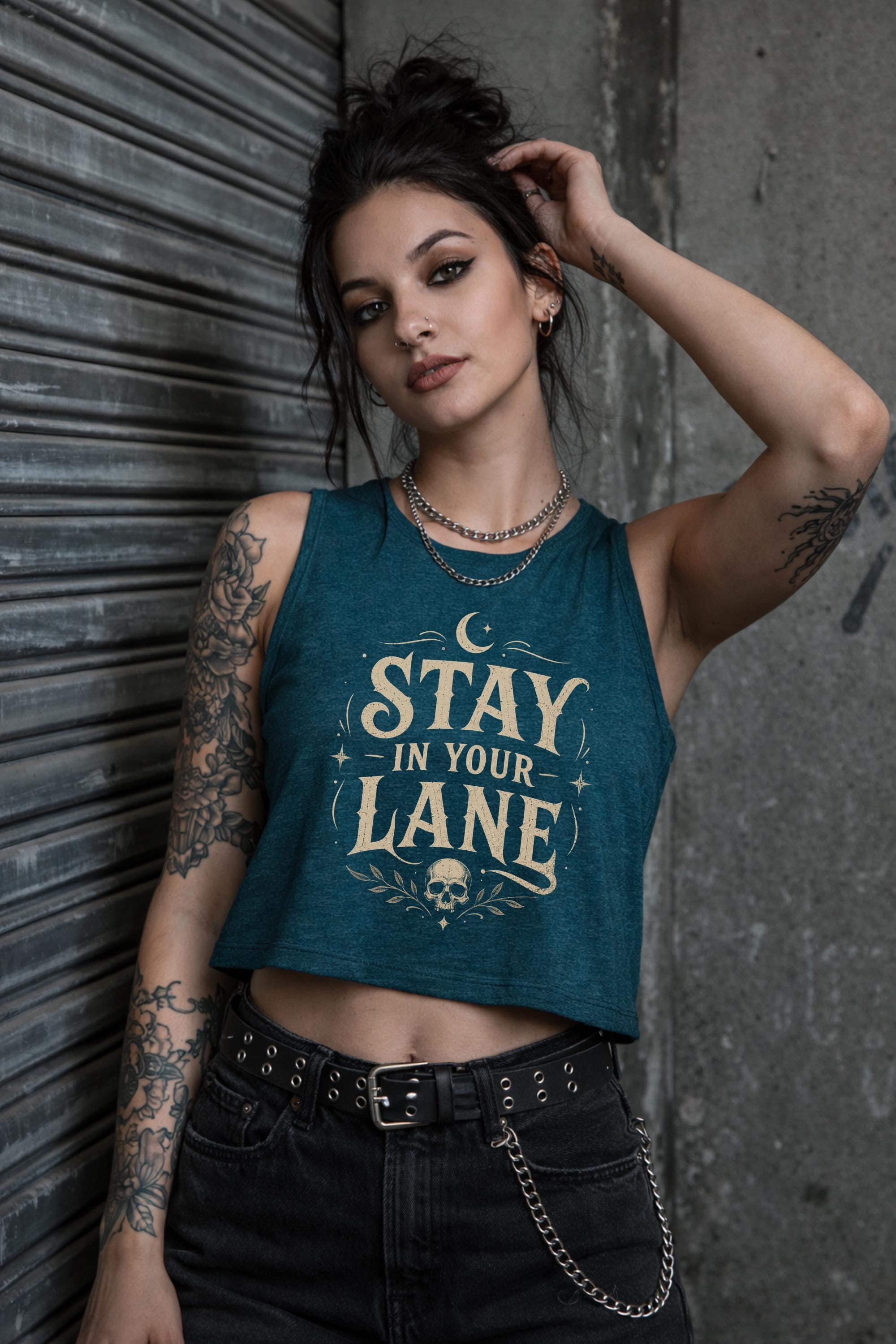 Woman wearing cropped Stay In Your Lane graphic tank with bold gothic lettering and alternative fashion styling