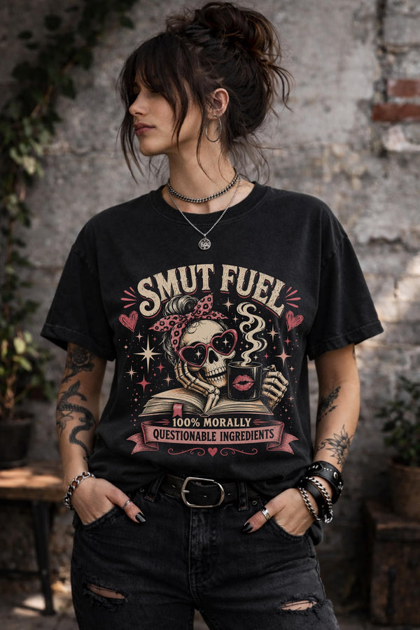 Smut Fuel graphic tee featuring skeleton reader with coffee mug and dark romance theme