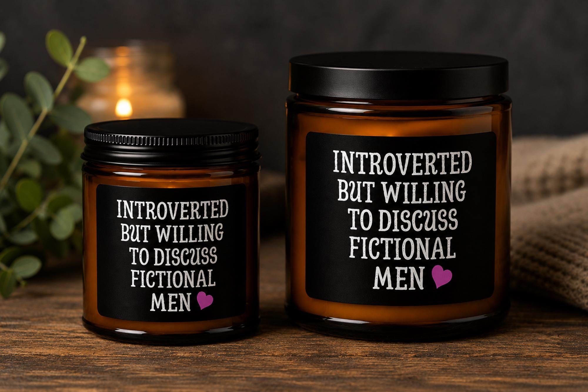 Dark romance themed scented soy candles featuring the phrase "Introverted But Willing To Discuss Fictional Men" displayed alongside gothic books and candlelit decor.