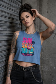 Woman modeling  crop tank top featuring colorful retro flamingo graphic with Sun Sand Salad Zero Fcks Given summer vacation design against urban industrial background.