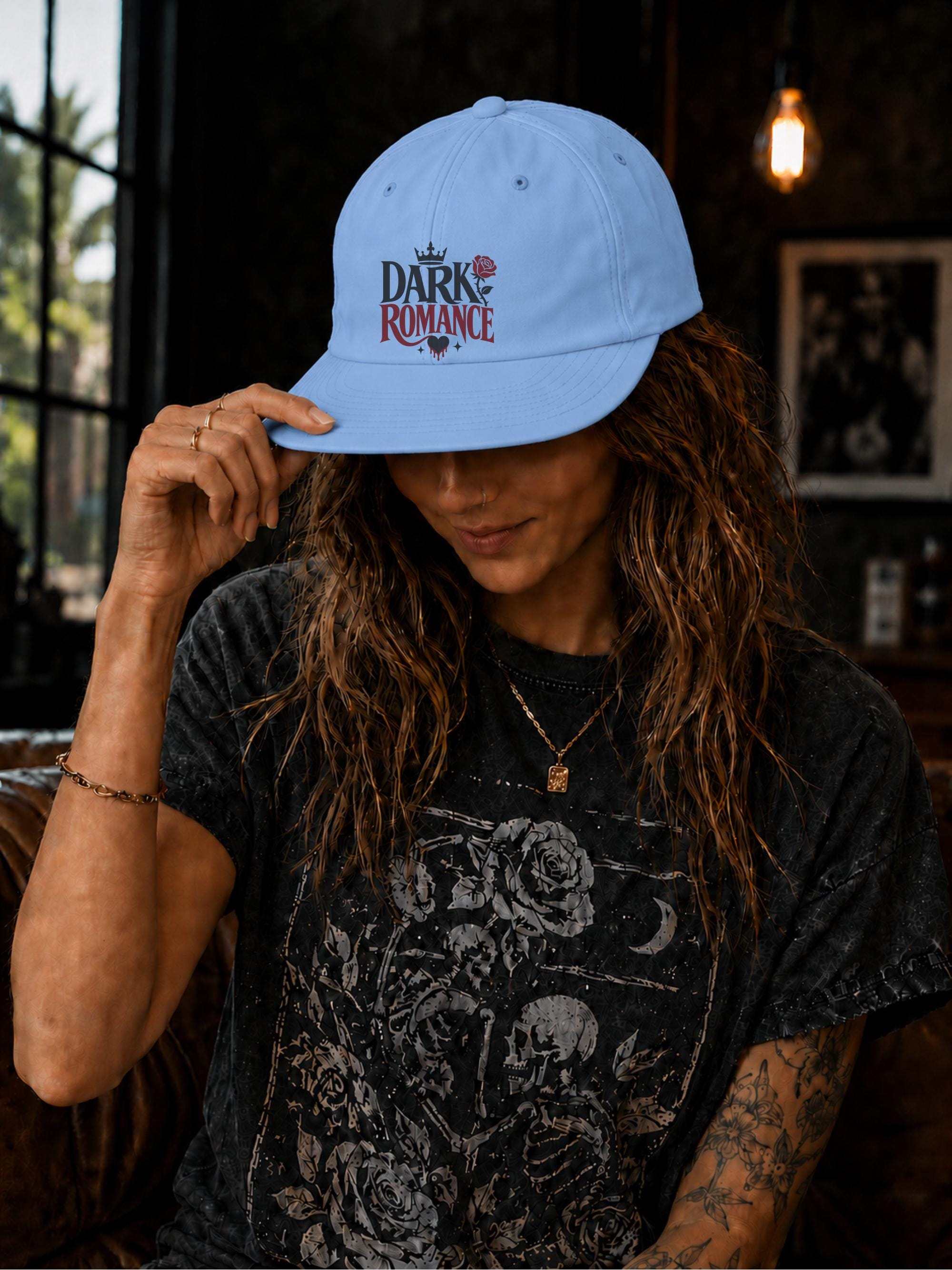Woman wearing a surf cap featuring a Dark Romance graphic with red rose detail, photographed in a moody bookish setting with dark academia aesthetic.