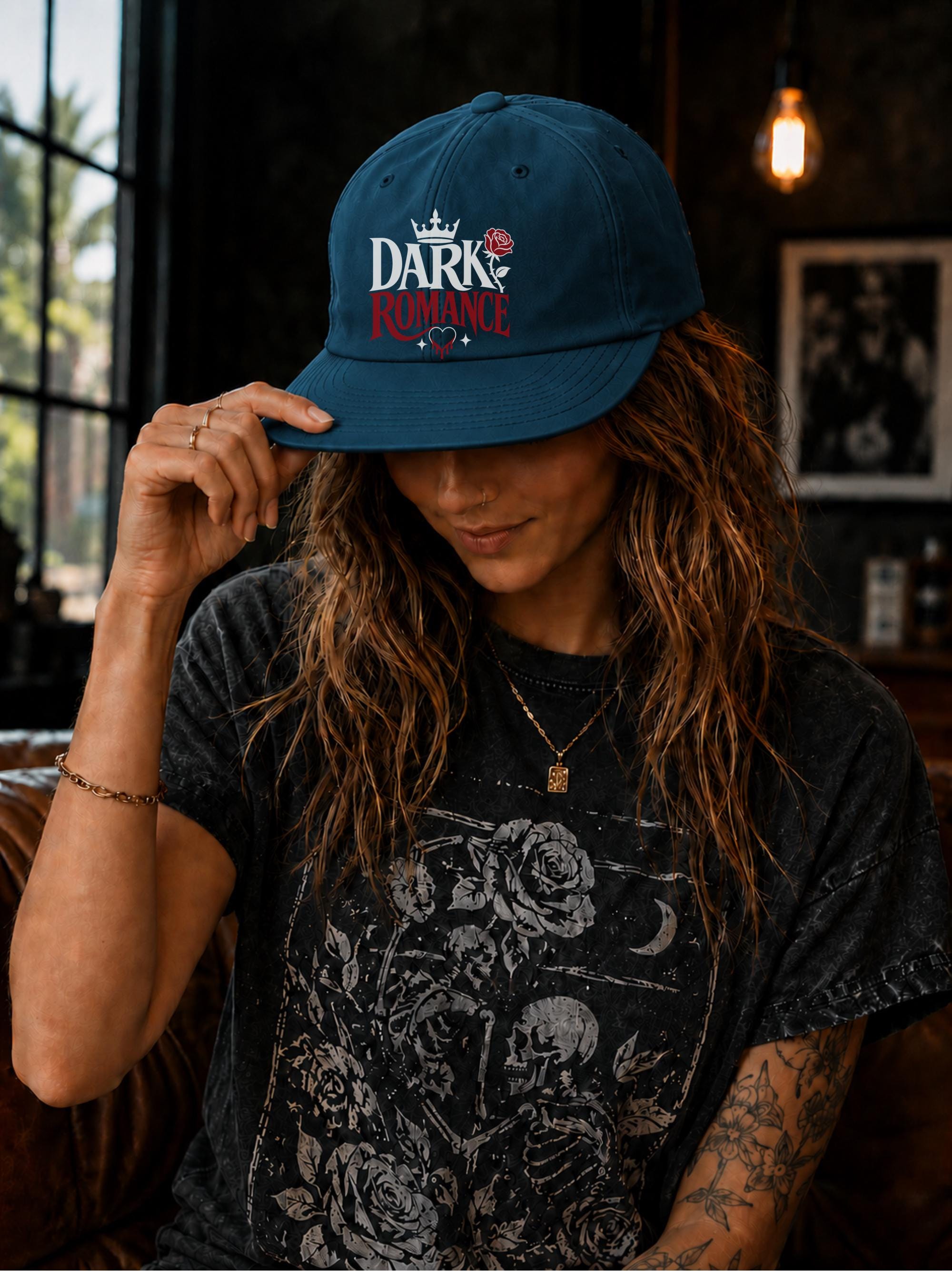 Woman wearing a surf cap featuring a Dark Romance graphic with red rose detail, photographed in a moody bookish setting with dark academia aesthetic.