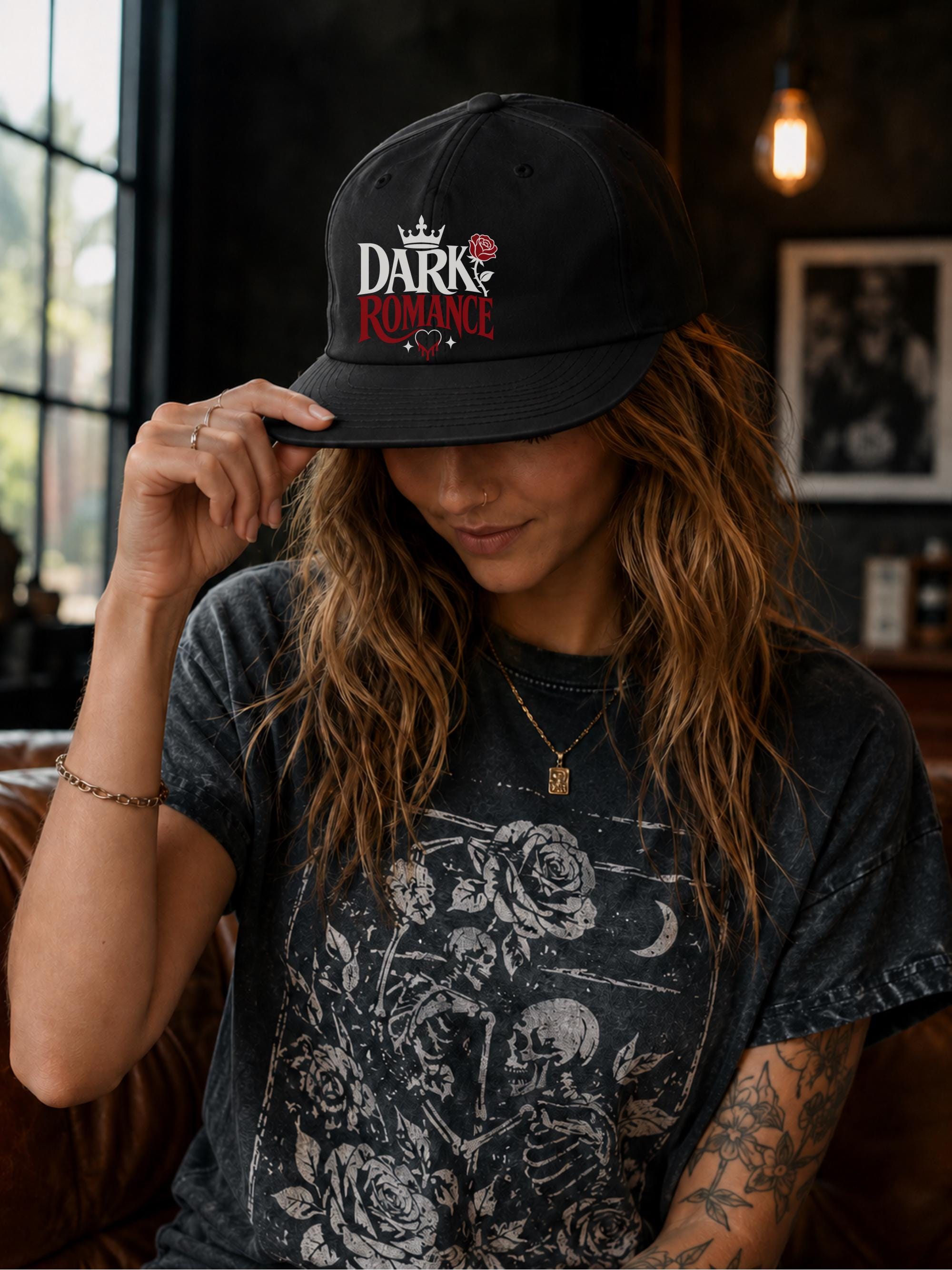 Woman wearing a black surf cap featuring a Dark Romance graphic with red rose detail, photographed in a moody bookish setting with dark academia aesthetic.