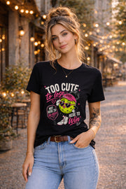Woman wearing a black Too Cute To Lose pickleball graphic t-shirt featuring a stylish pickleball character with heart sunglasses, pink visor, paddle artwork, and playful court-inspired design.