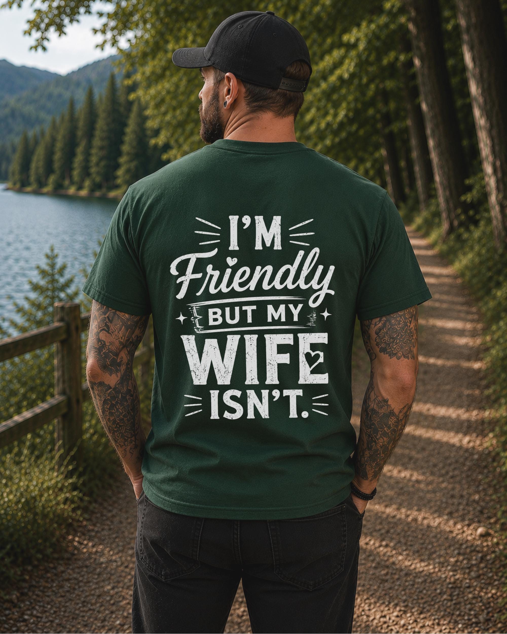 Back view of a black shirt featuring the humorous phrase "I'm Friendly But My Wife Isn't" in distressed white typography.