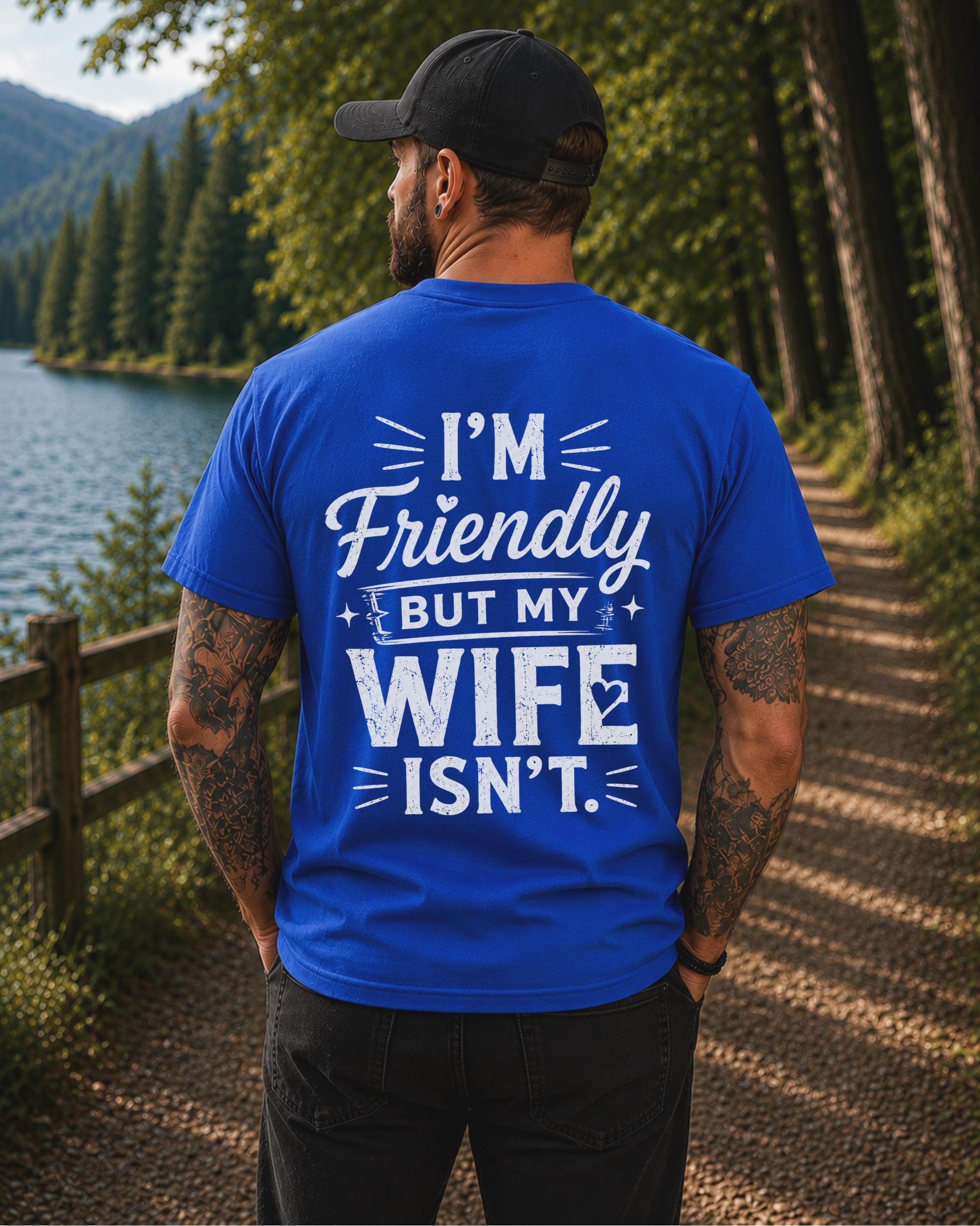 Back view of a black shirt featuring the humorous phrase "I'm Friendly But My Wife Isn't" in distressed white typography.