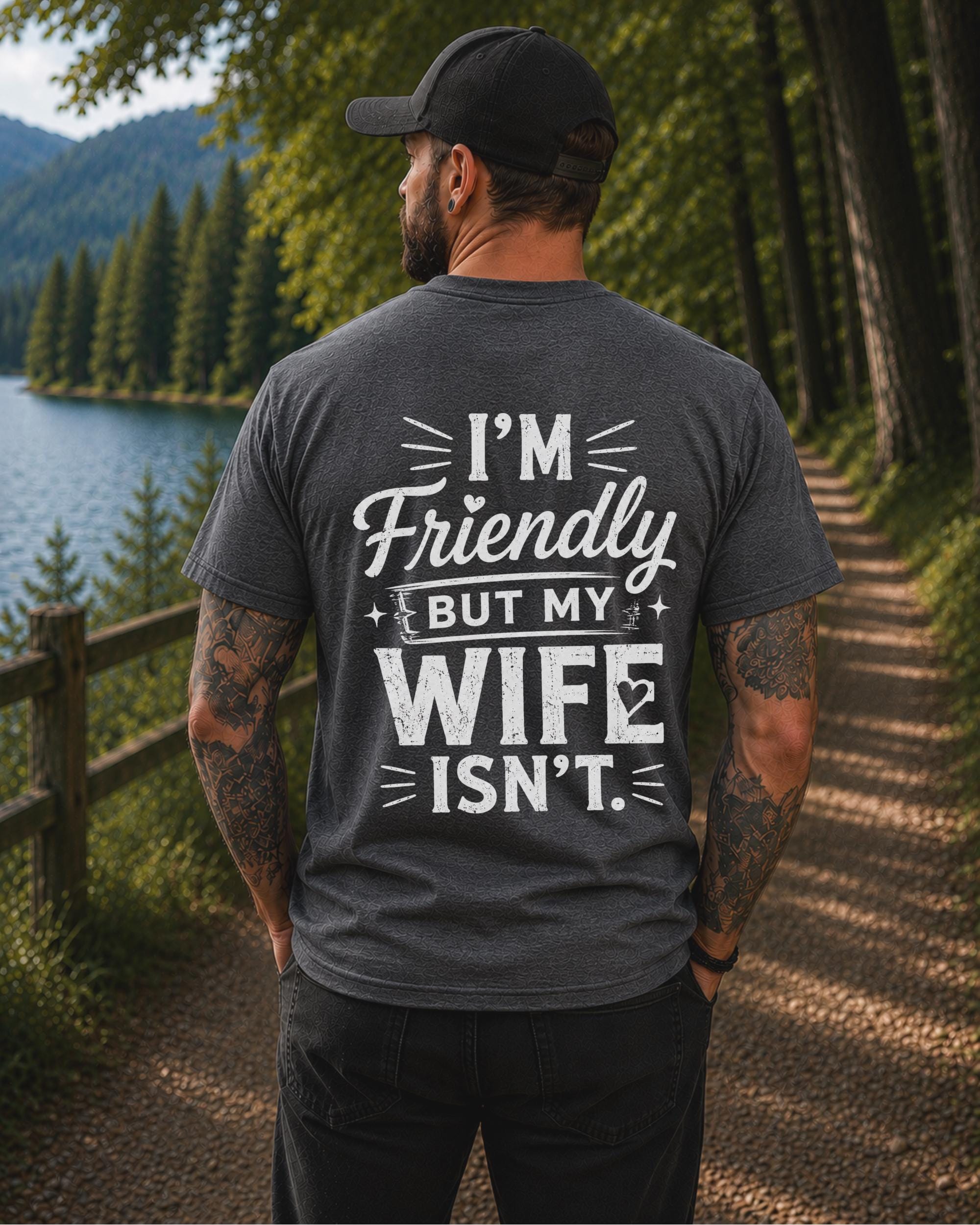 Back view of a black shirt featuring the humorous phrase "I'm Friendly But My Wife Isn't" in distressed white typography.