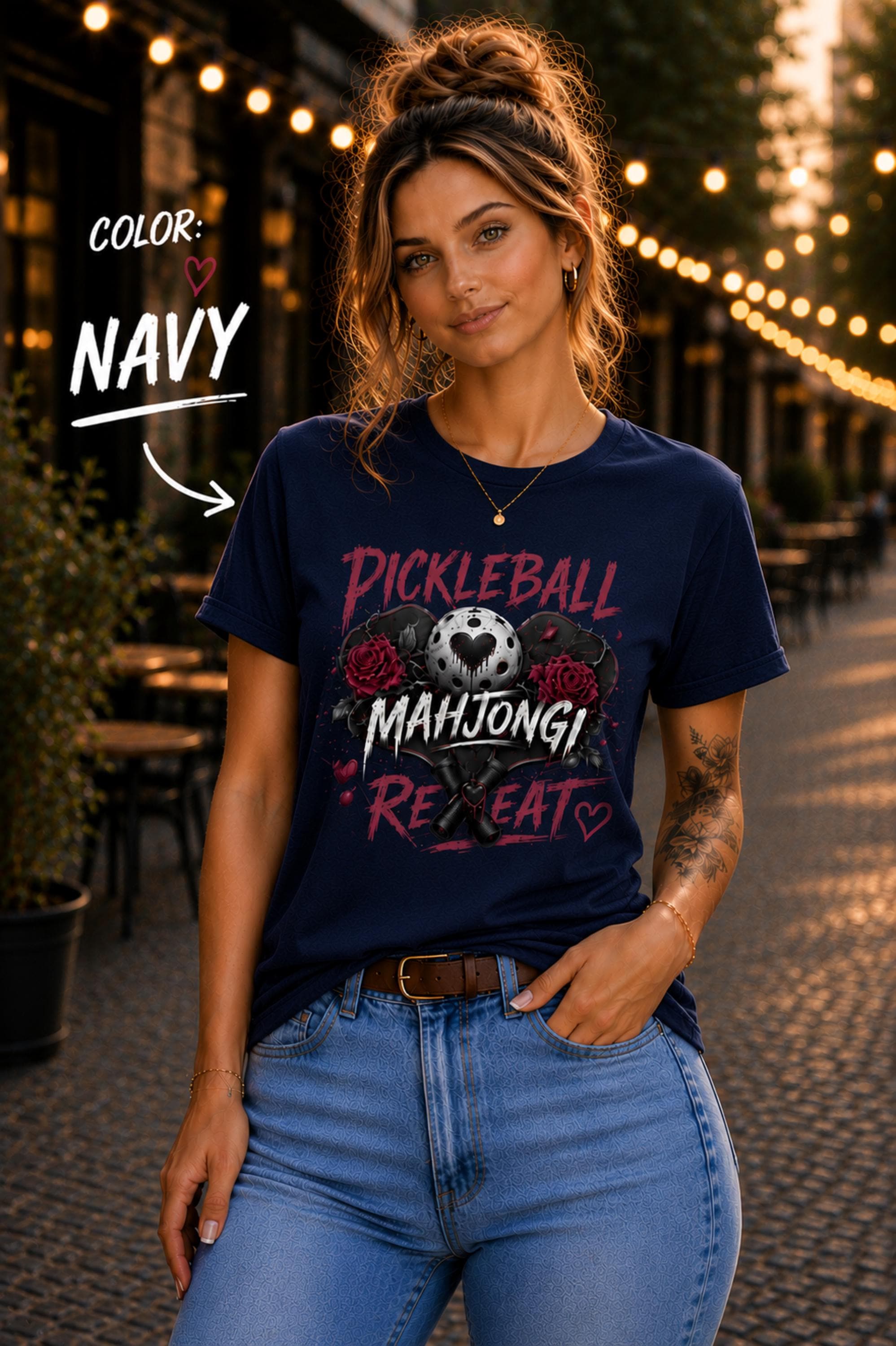 short-sleeve t-shirt featuring a graphic print with the text "PICKLEBALL MAHJONG REPEAT". The design includes a central pickleball with a heart cutout, flanked by two red roses, and two crossed pickleball paddles below.