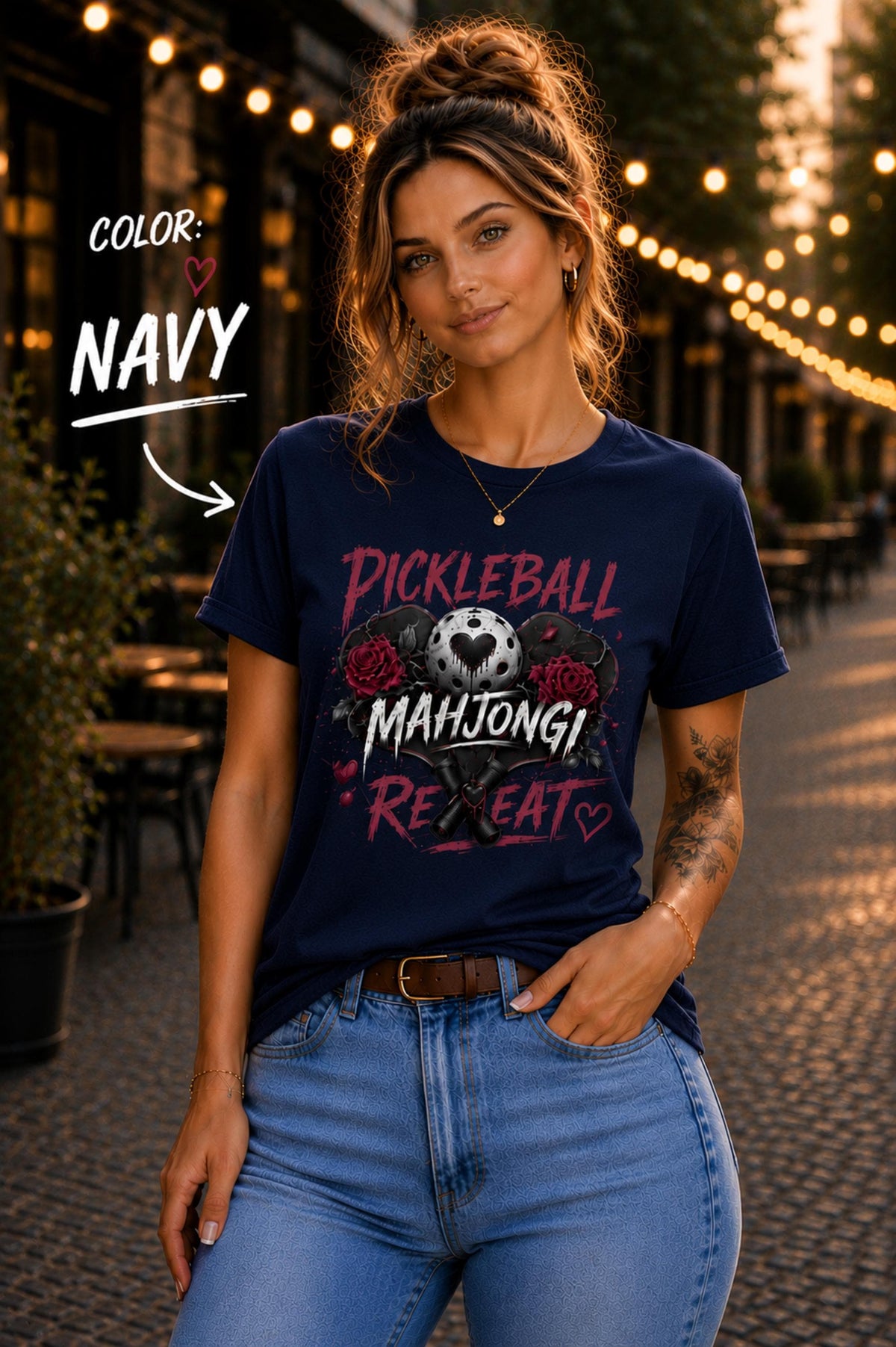short-sleeve t-shirt featuring a graphic print with the text "PICKLEBALL MAHJONG REPEAT". The design includes a central pickleball with a heart cutout, flanked by two red roses, and two crossed pickleball paddles below.