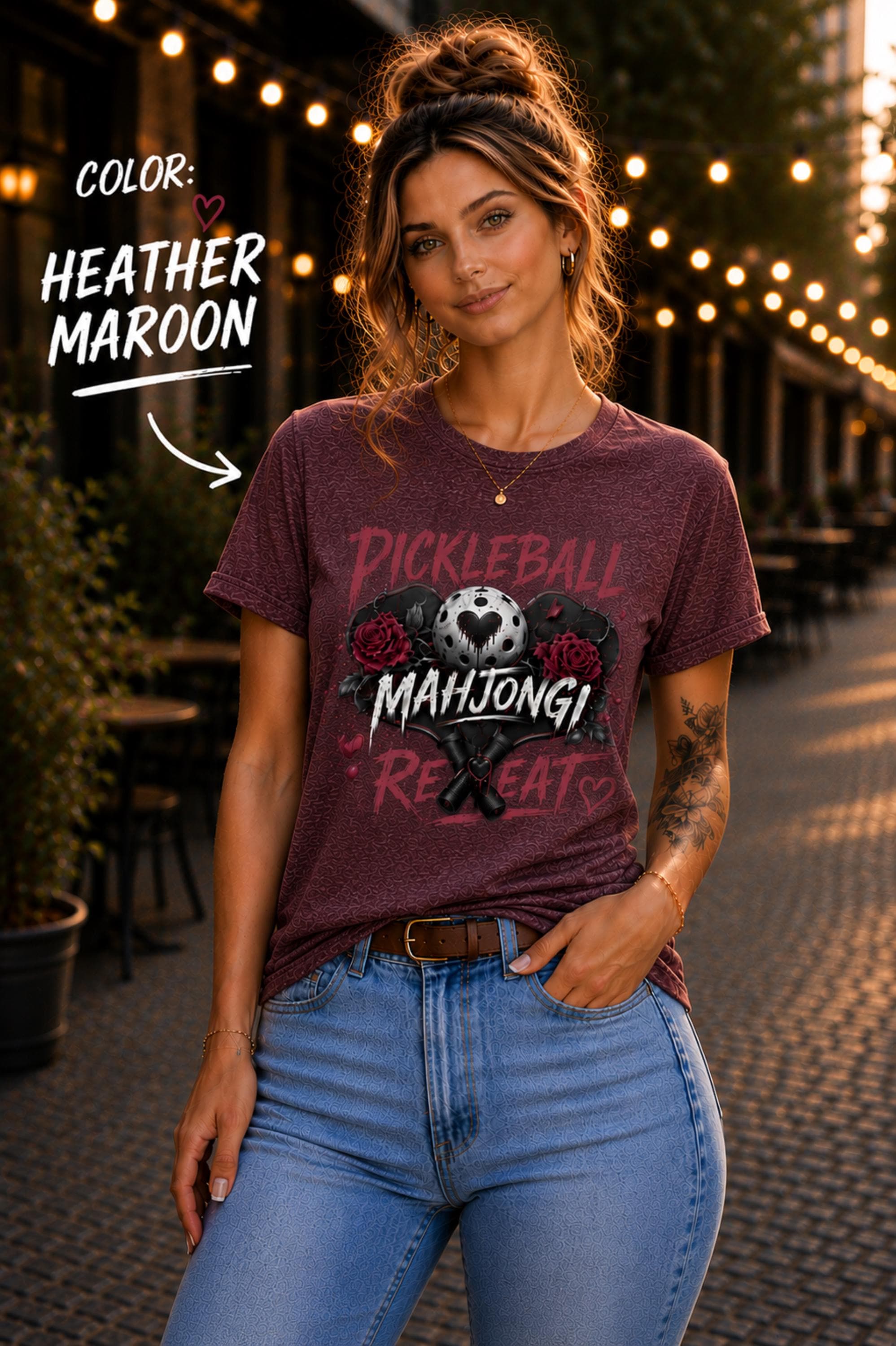 short-sleeve t-shirt featuring a graphic print with the text "PICKLEBALL MAHJONG REPEAT". The design includes a central pickleball with a heart cutout, flanked by two red roses, and two crossed pickleball paddles below.