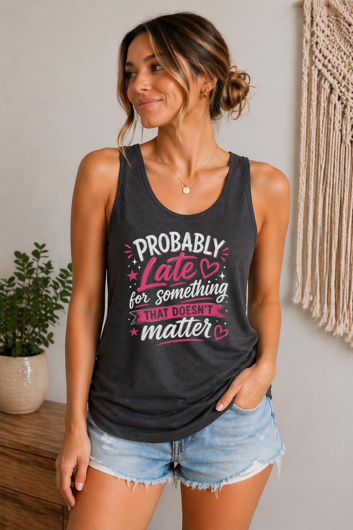 Woman wearing a dark heather Bella Canvas tank top featuring the phrase "Probably Late for Something That Doesn't Matter" in pink and white typography.