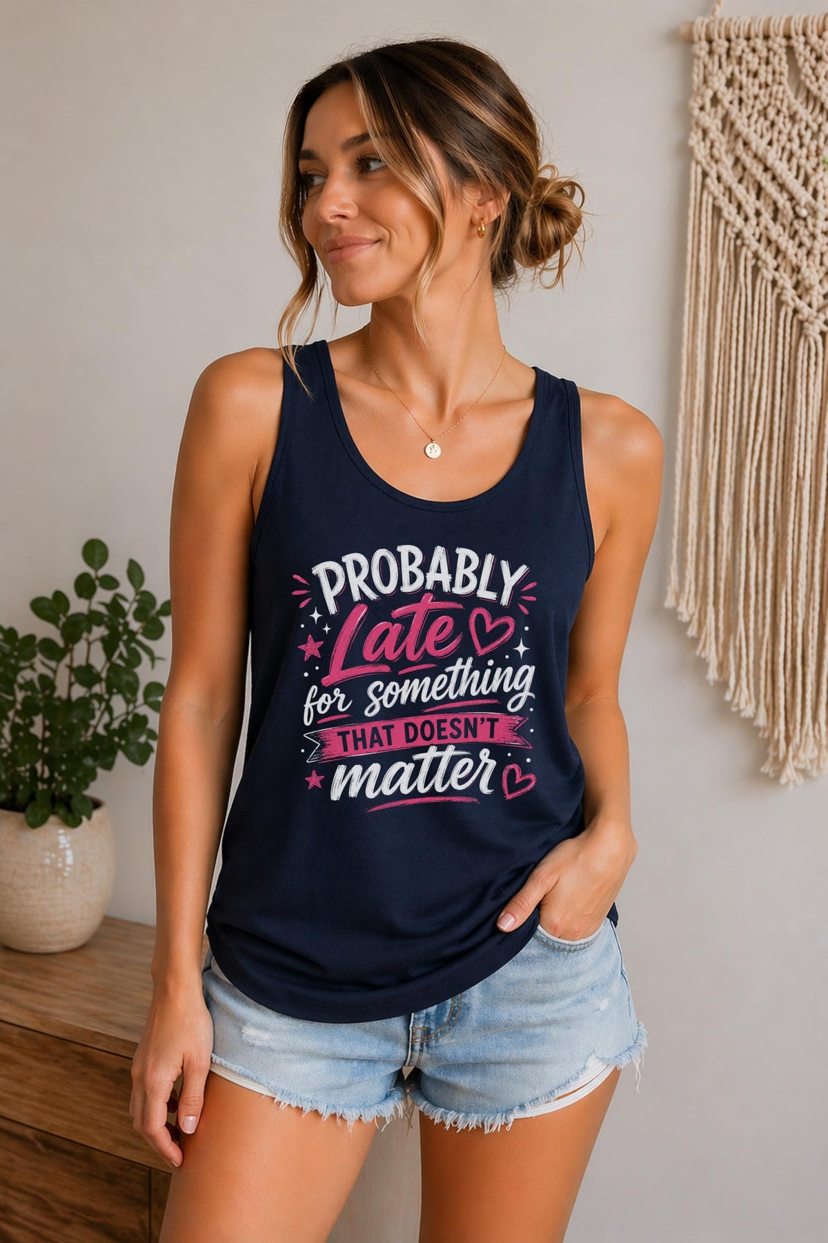 Woman wearing a navy Bella Canvas tank top featuring the phrase "Probably Late for Something That Doesn't Matter" in pink and white typography.