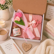 Teacher appreciation gift box featuring a blush pink knit blanket, Best Teacher Ever candle, crochet flower bouquet, and pink bow clip arranged in elegant gift-ready packaging.