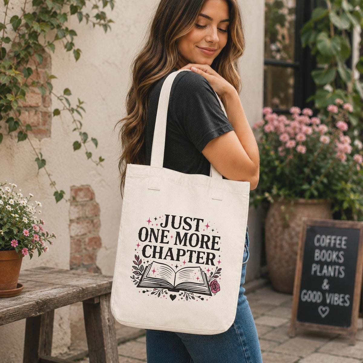 Woman carrying Just One More Chapter book lover tote bag outside bookstore café