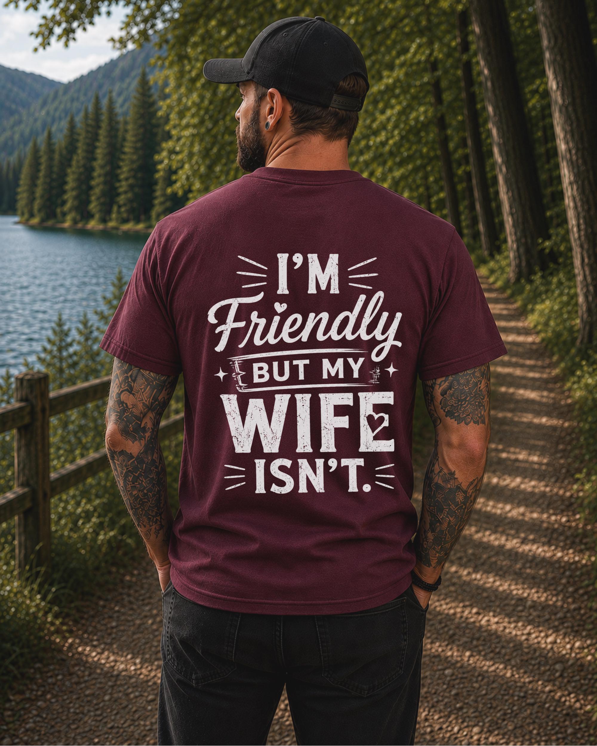 Back view of a black shirt featuring the humorous phrase "I'm Friendly But My Wife Isn't" in distressed white typography.