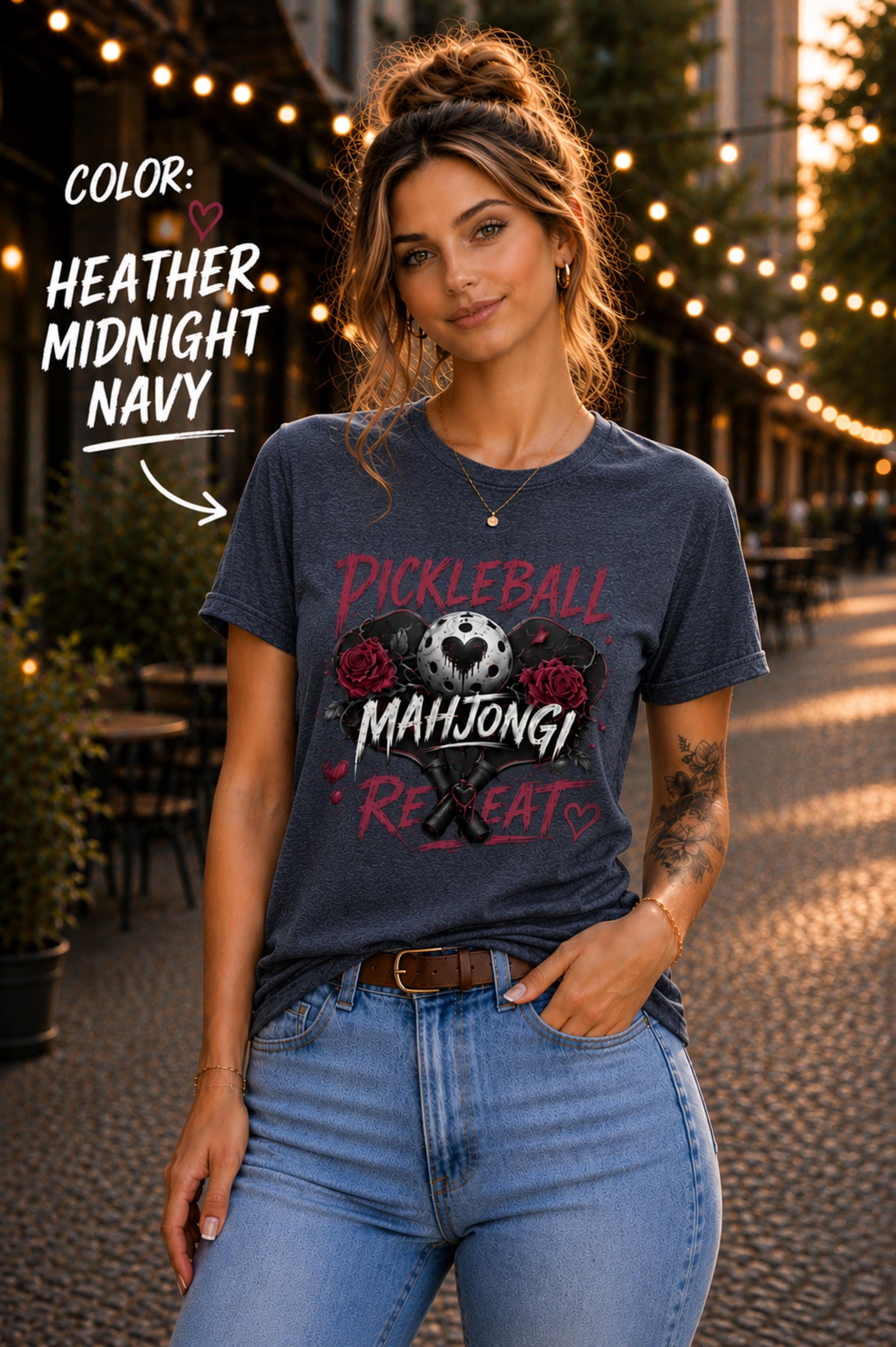 short-sleeve t-shirt featuring a graphic print with the text "PICKLEBALL MAHJONG REPEAT". The design includes a central pickleball with a heart cutout, flanked by two red roses, and two crossed pickleball paddles below.