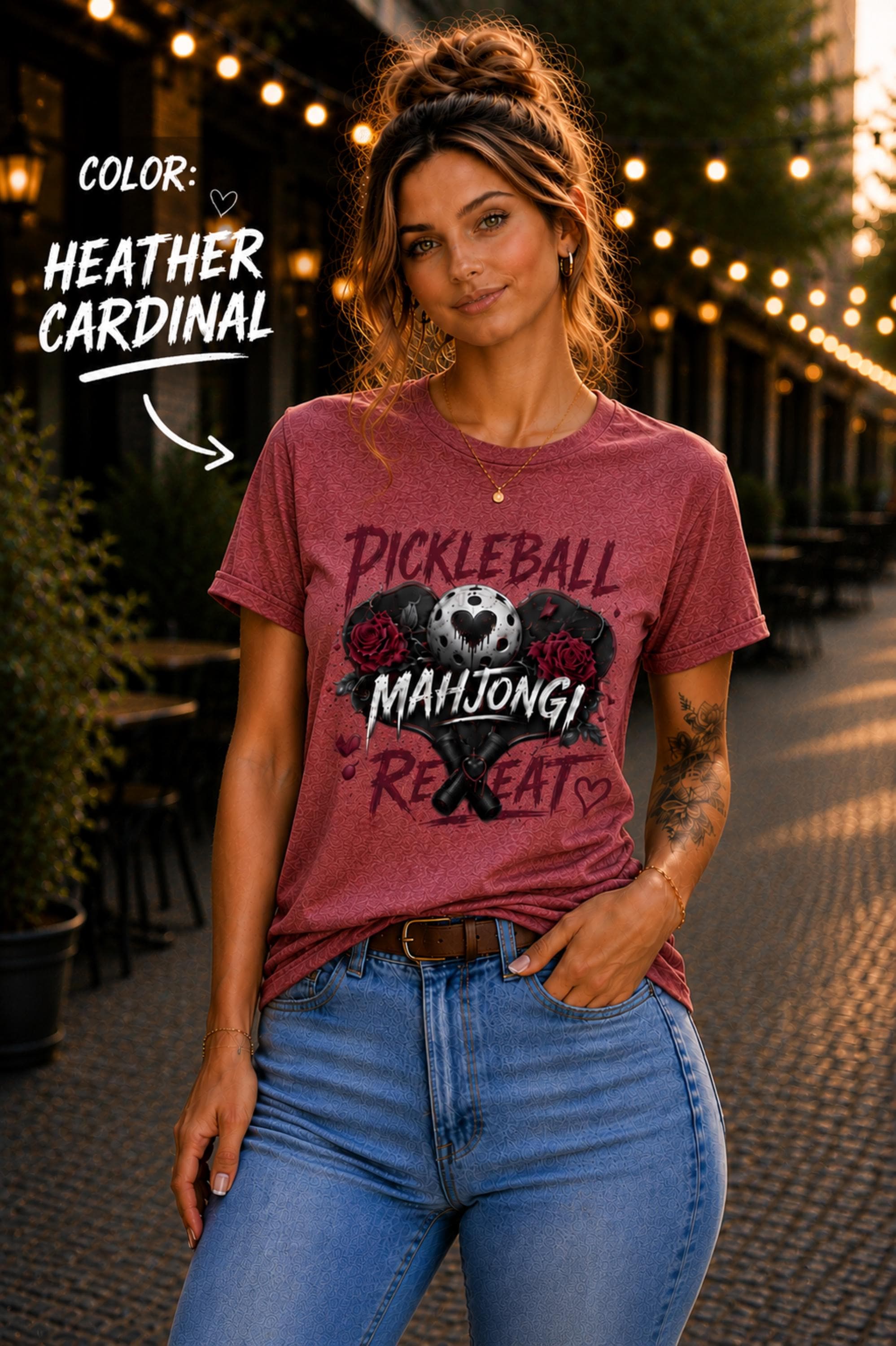 short-sleeve t-shirt featuring a graphic print with the text "PICKLEBALL MAHJONG REPEAT". The design includes a central pickleball with a heart cutout, flanked by two red roses, and two crossed pickleball paddles below.