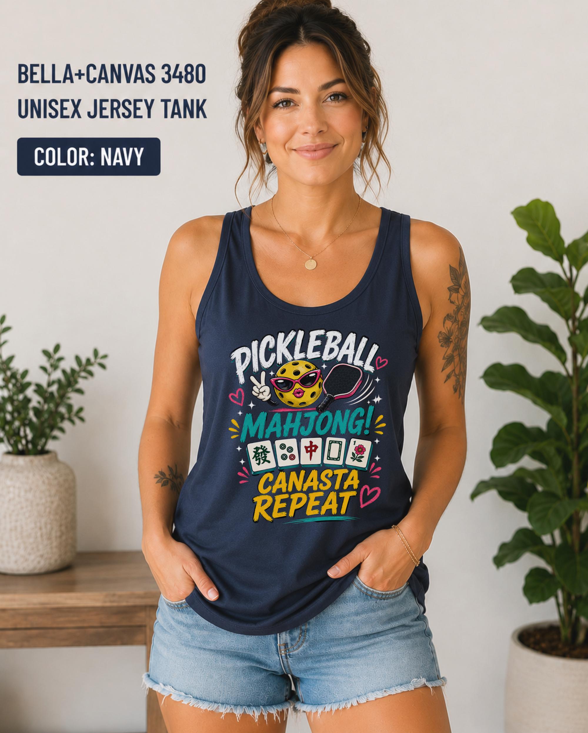 Woman wearing a navy Bella+Canvas 3480 jersey tank featuring a colorful "Pickleball Mahjong Canasta Repeat" graphic with a smiling pickleball character, paddle, and Mahjong tiles.