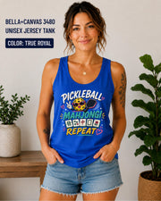 Woman wearing a true royal Bella+Canvas 3480 unisex jersey tank featuring a colorful "Pickleball Mahjong Repeat" graphic with a smiling pickleball, paddle, Mahjong tiles, and bright playful lettering.