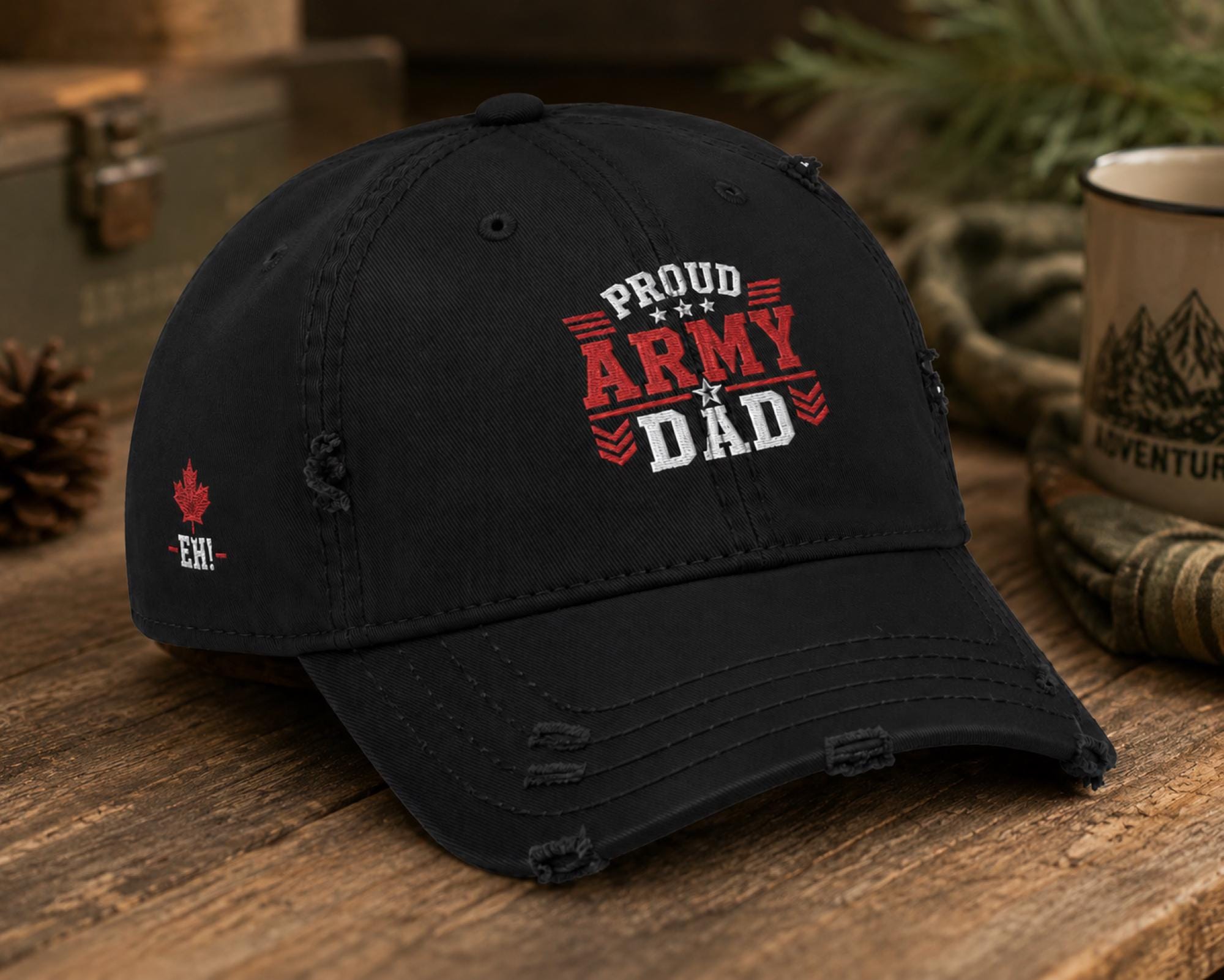 Black distressed embroidered dad hat featuring a bold "Proud Army Dad" design on the front with a red maple leaf and "EH!" embroidery on the side, styled in a rustic outdoor setting with camping accessories.