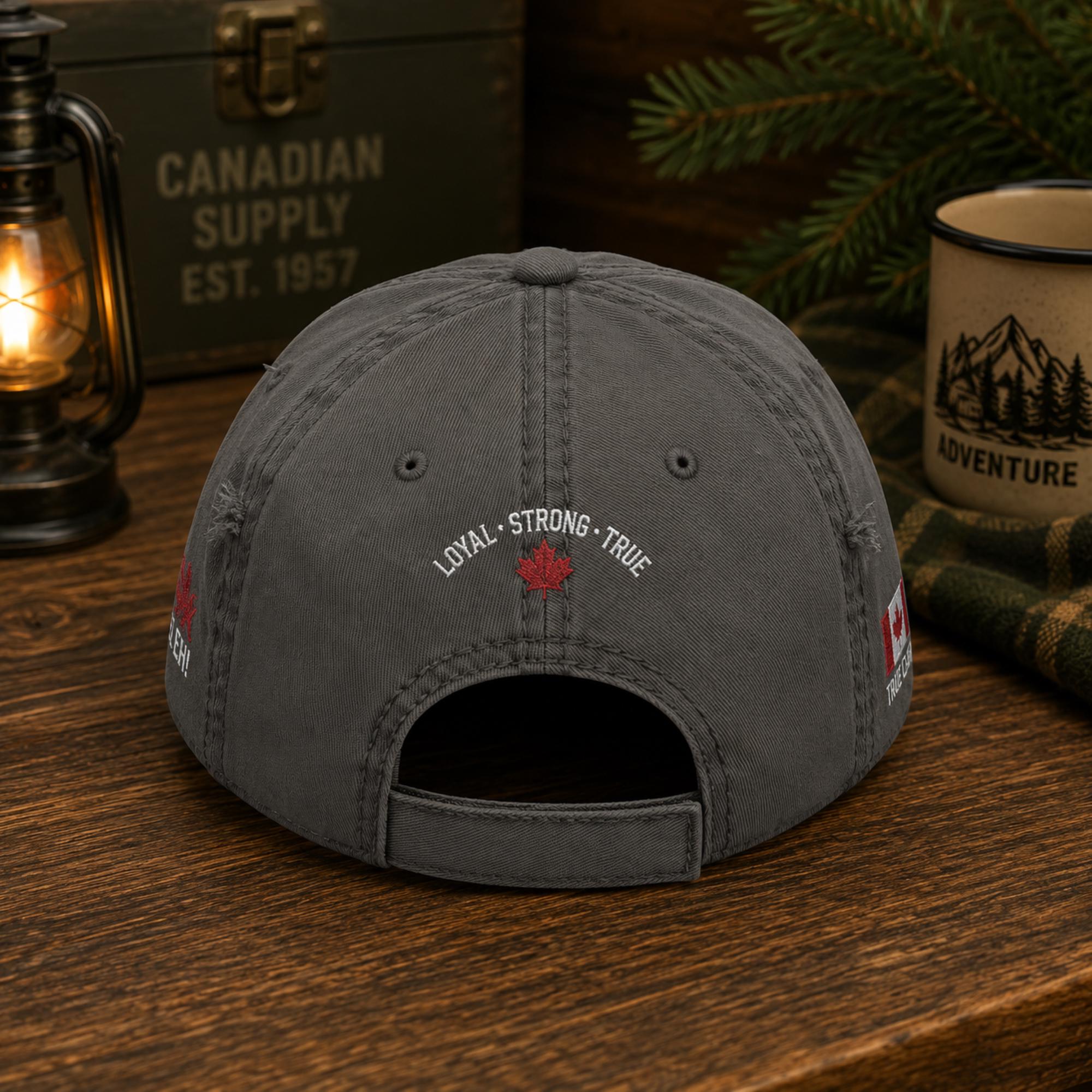 Charcoal distressed embroidered dad hat featuring "Proud Canadian Strong & Free" on the front with maple leaf accents, Canadian flag embroidery on the sides, and an EH! True North maple leaf detail in a rustic outdoor setting.