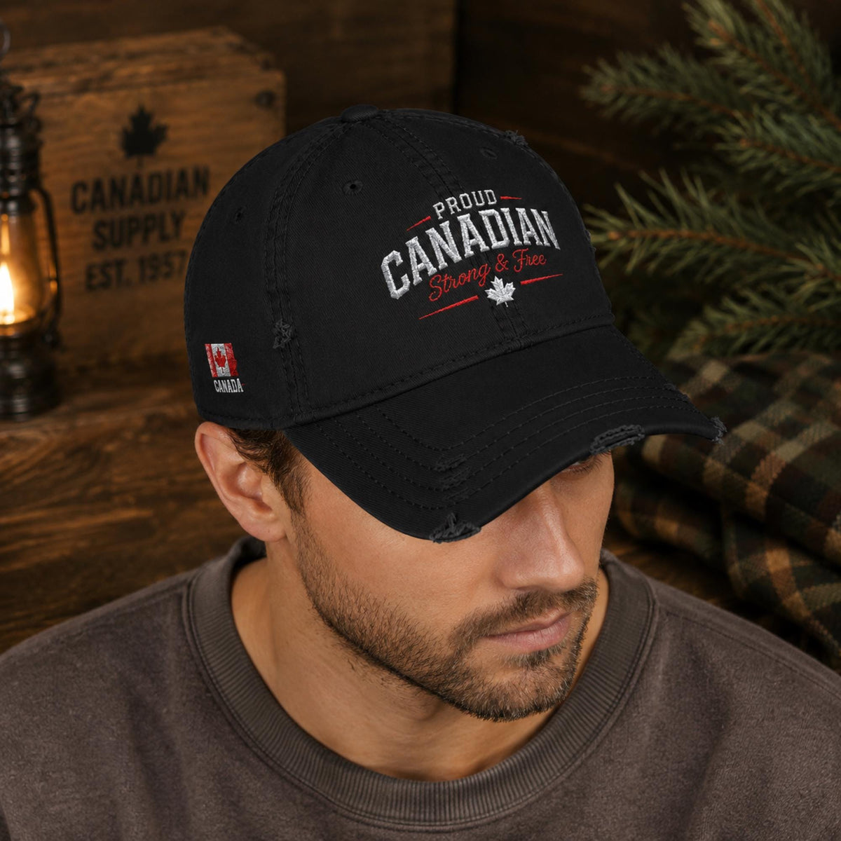 Black distressed embroidered dad hat featuring "Proud Canadian Strong & Free" on the front with maple leaf accents, Canadian flag embroidery on the side, and an EH! maple leaf detail in a rustic outdoor setting.