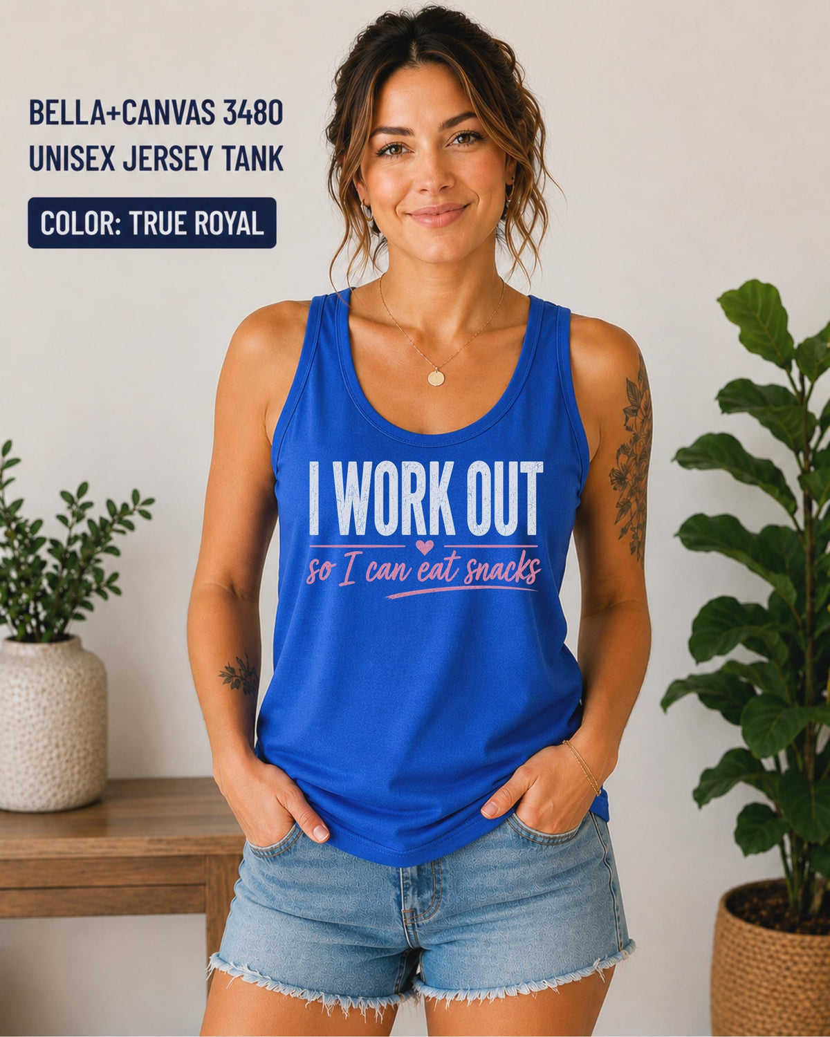 Woman wearing a true royal Bella+Canvas jersey tank featuring the phrase "I Work Out So I Can Eat Snacks" in white and pink lettering.