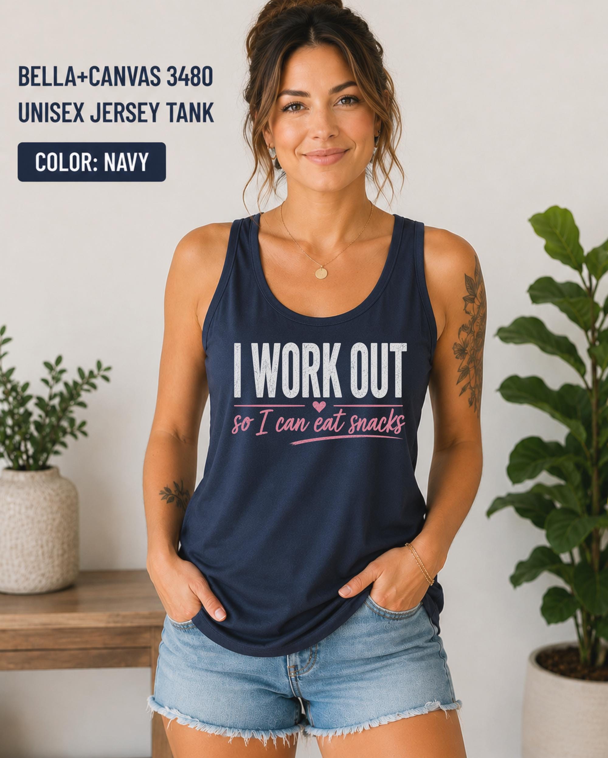 Woman wearing a navy Bella+Canvas jersey tank featuring the phrase "I Work Out So I Can Eat Snacks" in white and pink lettering.