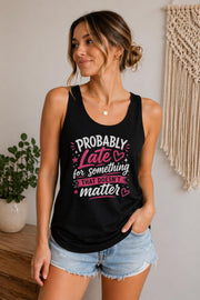 Woman wearing a black Bella Canvas tank top featuring the phrase "Probably Late for Something That Doesn't Matter" in pink and white typography.