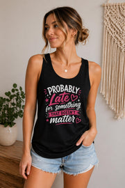Woman wearing a black Bella Canvas tank top featuring the phrase "Probably Late for Something That Doesn't Matter" in pink and white typography.