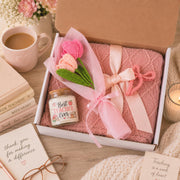 Teacher appreciation gift box featuring a blush pink knit blanket, Best Teacher Ever candle, crochet flower bouquet, and pink bow clip arranged in elegant gift-ready packaging.