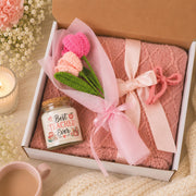 Teacher appreciation gift box featuring a blush pink knit blanket, Best Teacher Ever candle, crochet flower bouquet, and pink bow clip arranged in elegant gift-ready packaging.