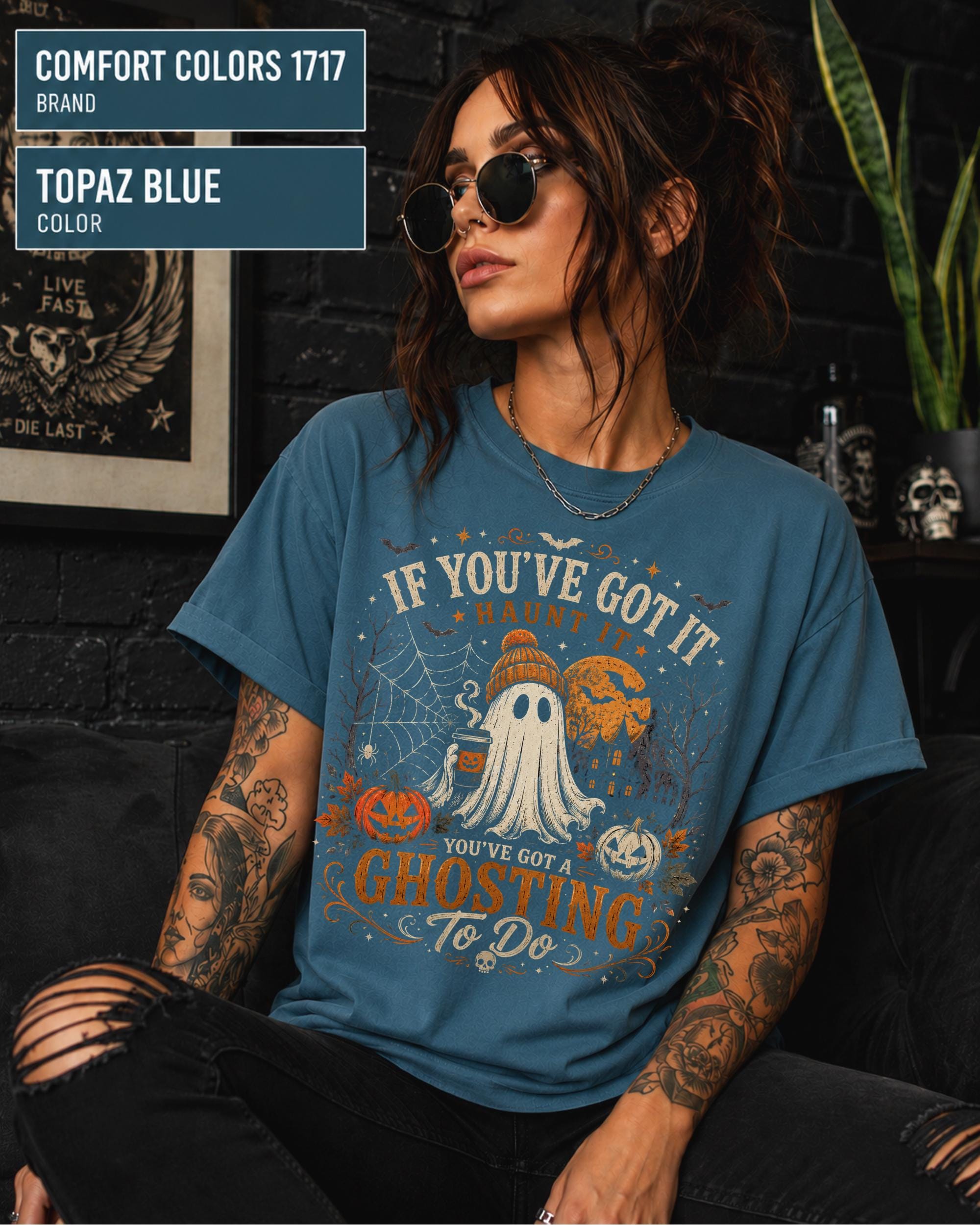 Woman wearing a Comfort Colors 1717 Topaz Blue T-shirt featuring a vintage Halloween ghost design with pumpkins, spiderwebs, haunted house, moon, bats, and the funny quote "If You've Got It Haunt It... You've Got a Ghosting To Do."