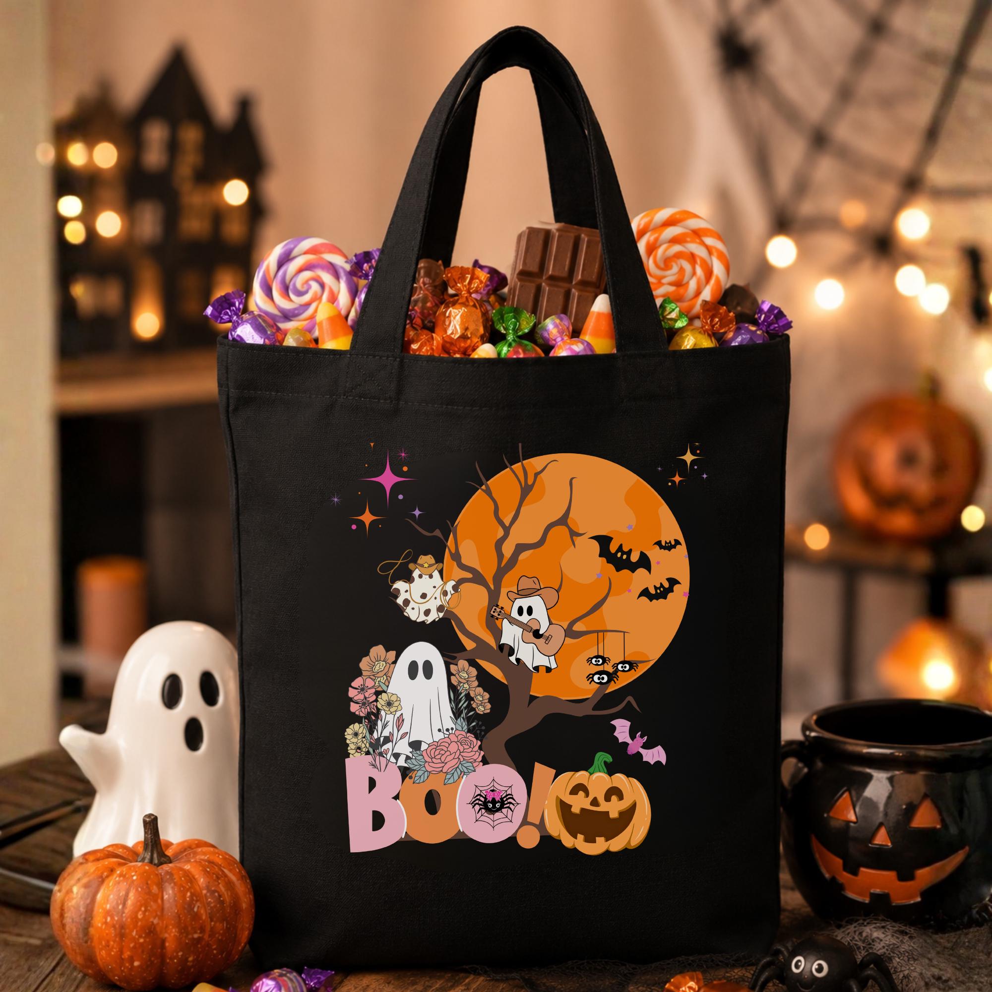 May include: Black tote bag with a Halloween design featuring a ghost, a pumpkin, and bats in front of a full moon. The text "BOO!" is printed on the bag.