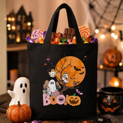 May include: Black tote bag with a Halloween design featuring a ghost, a pumpkin, and bats in front of a full moon. The text "BOO!" is printed on the bag.