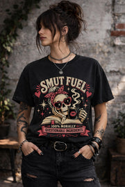 Smut Fuel graphic tee featuring a skeleton reader with a coffee mug and dark romance theme