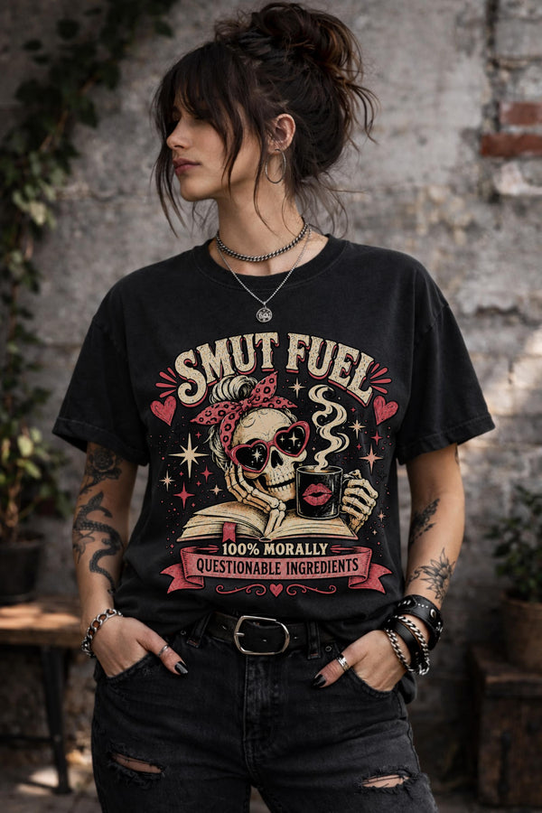Smut Fuel graphic tee featuring a skeleton reader with a coffee mug and dark romance theme