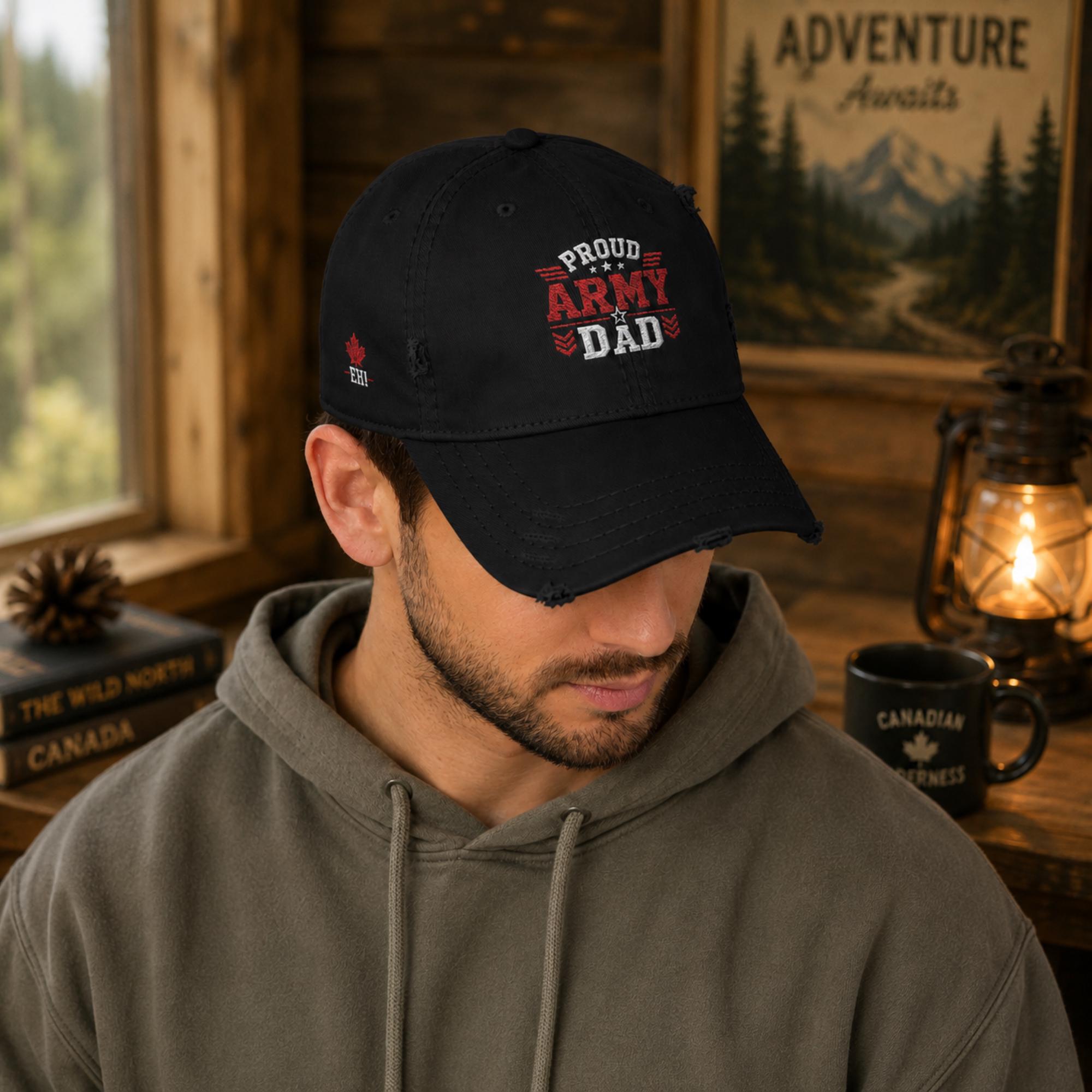 Black distressed embroidered dad hat featuring a bold "Proud Army Dad" design on the front with a red maple leaf and "EH!" embroidery on the side, styled in a rustic outdoor setting with camping accessories.
