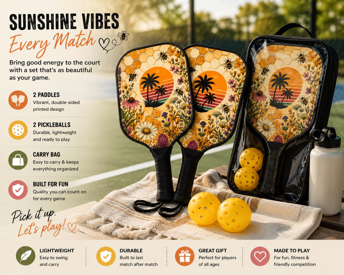 Tropical pickleball paddle with bees, wildflowers, palm tree sunset, and honeycomb artwork on an outdoor court.